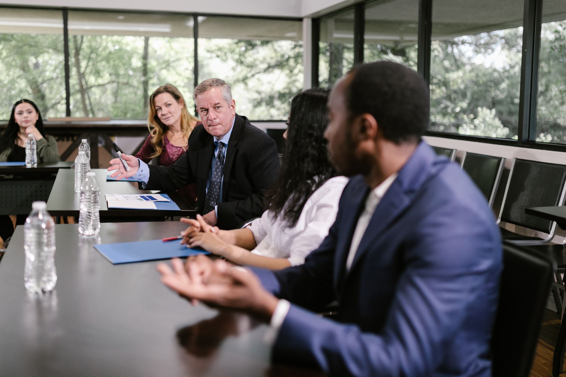 A diverse group of professionals engaging in a collaborative meeting in a conference room setting — UPI Study