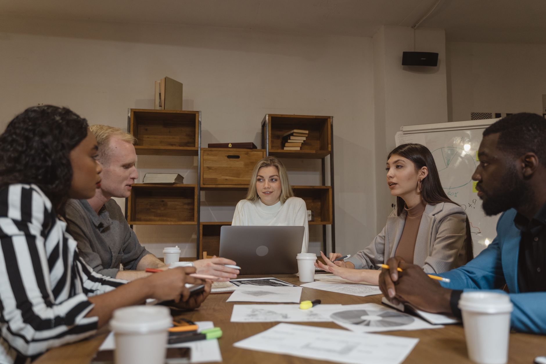 Group of professionals collaborating in a modern office setting during a strategic meeting — UPI Study