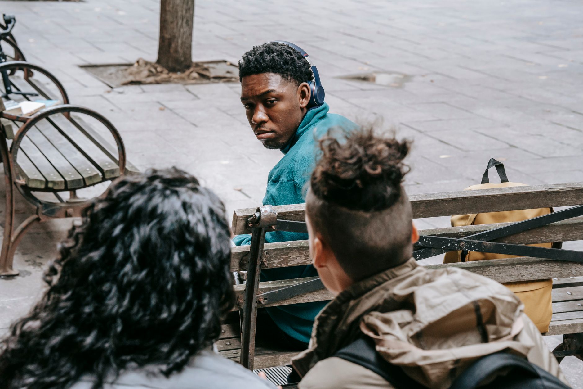 Back view of anonymous classmates sitting behind black friend and gossiping on schoolyard — UPI Study
