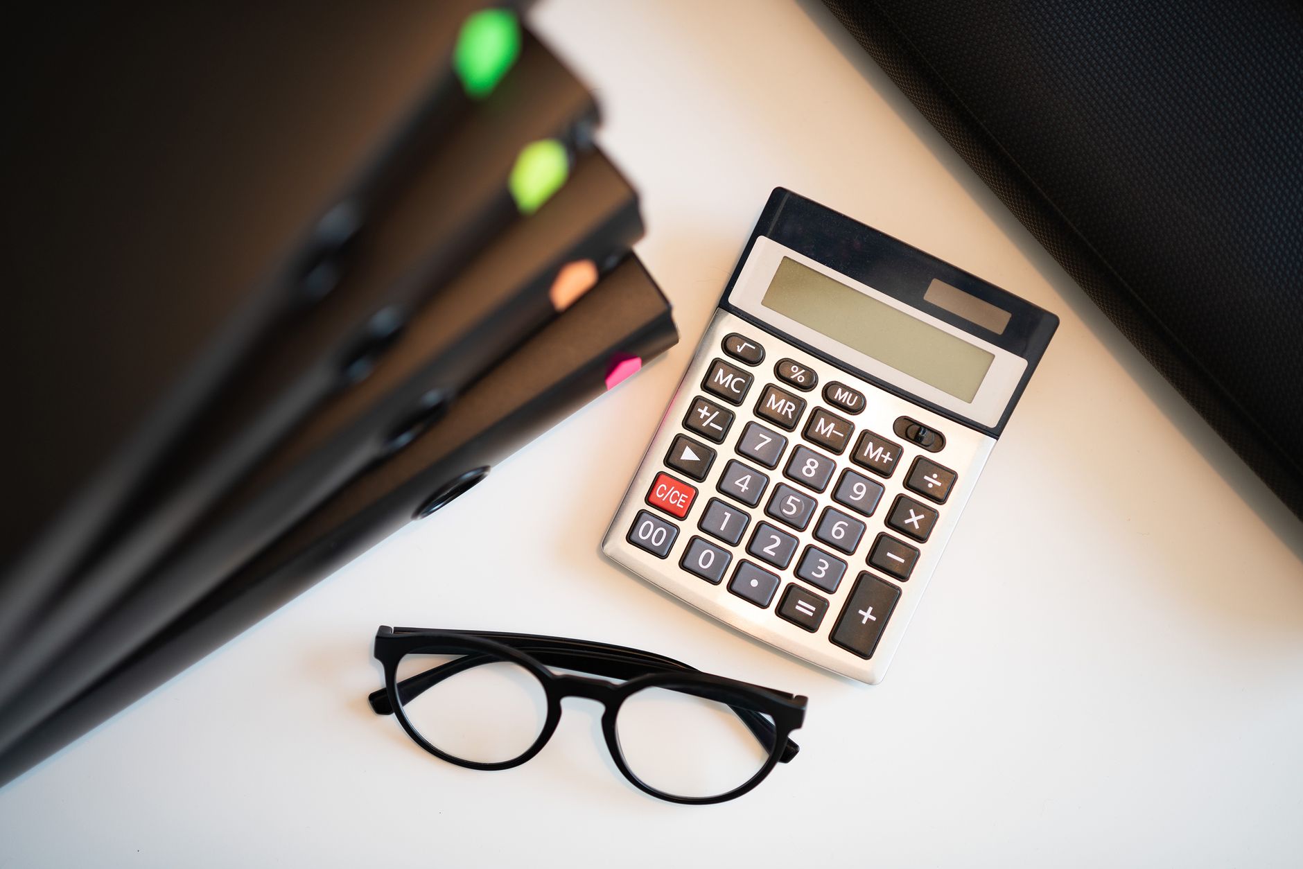 Calculator with glasses and folders on an office desk. Perfect for finance and accounting themes — UPI Study