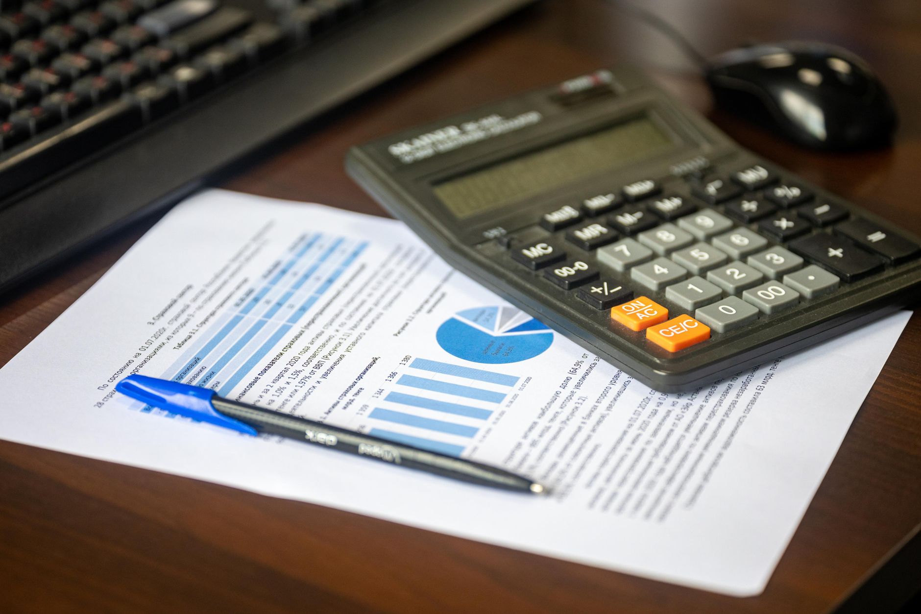 Desk with calculator, financial report, and pen, suggesting business analysis — UPI Study