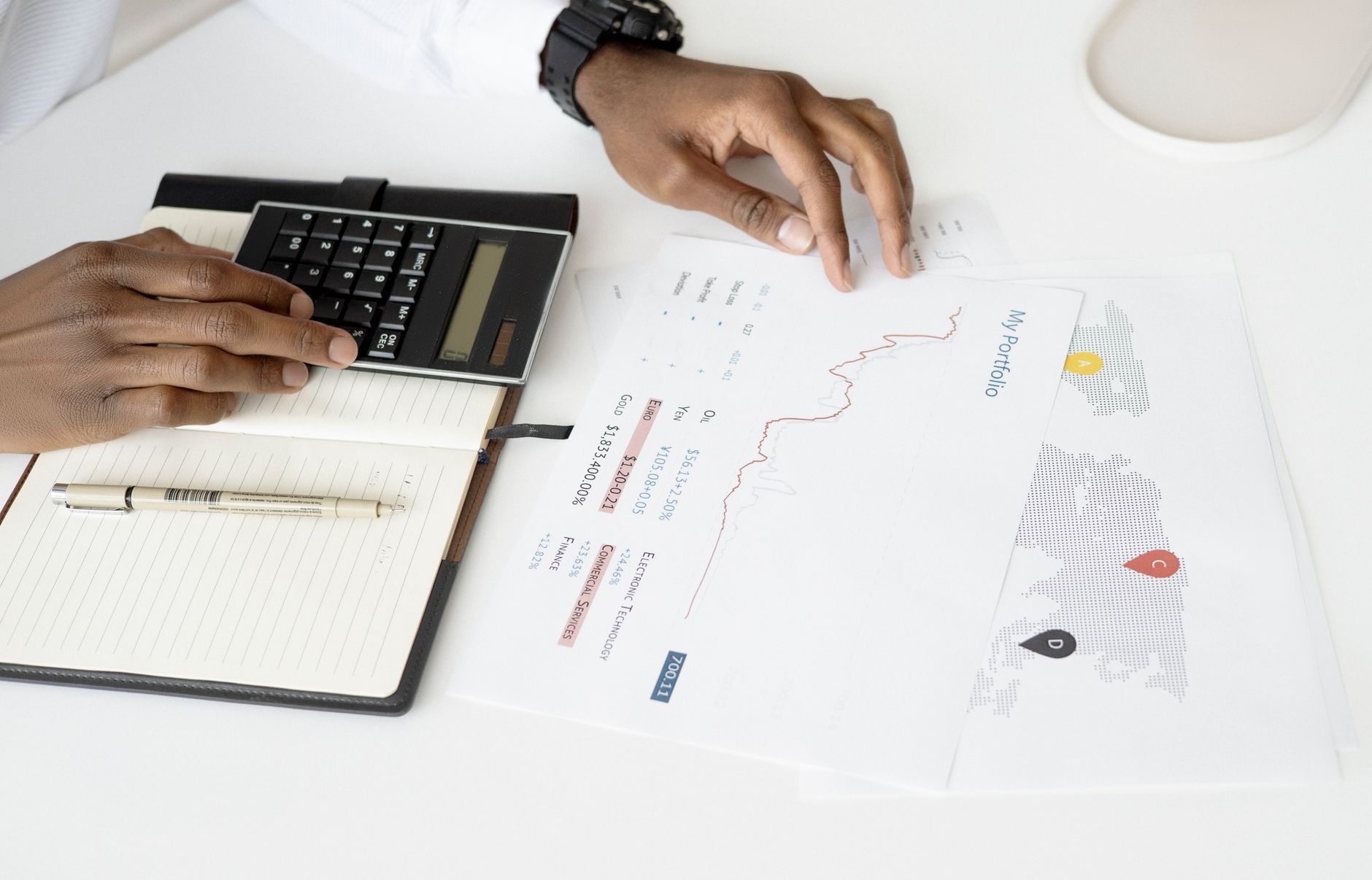 Overhead view of a person analyzing financial documents using a calculator for investment planning — UPI Study