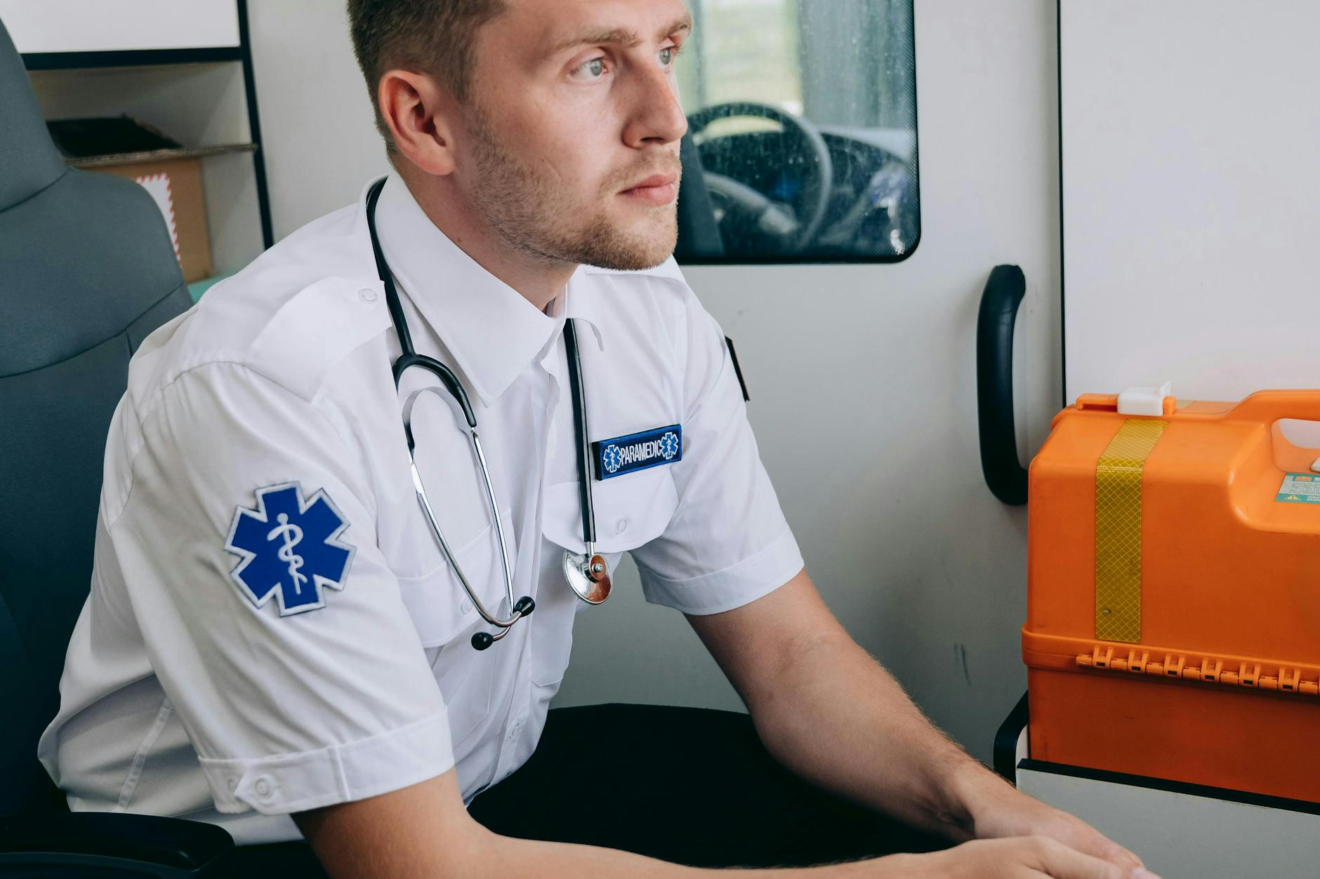 A thoughtful paramedic with stethoscope inside an ambulance, ready to assist — UPI Study