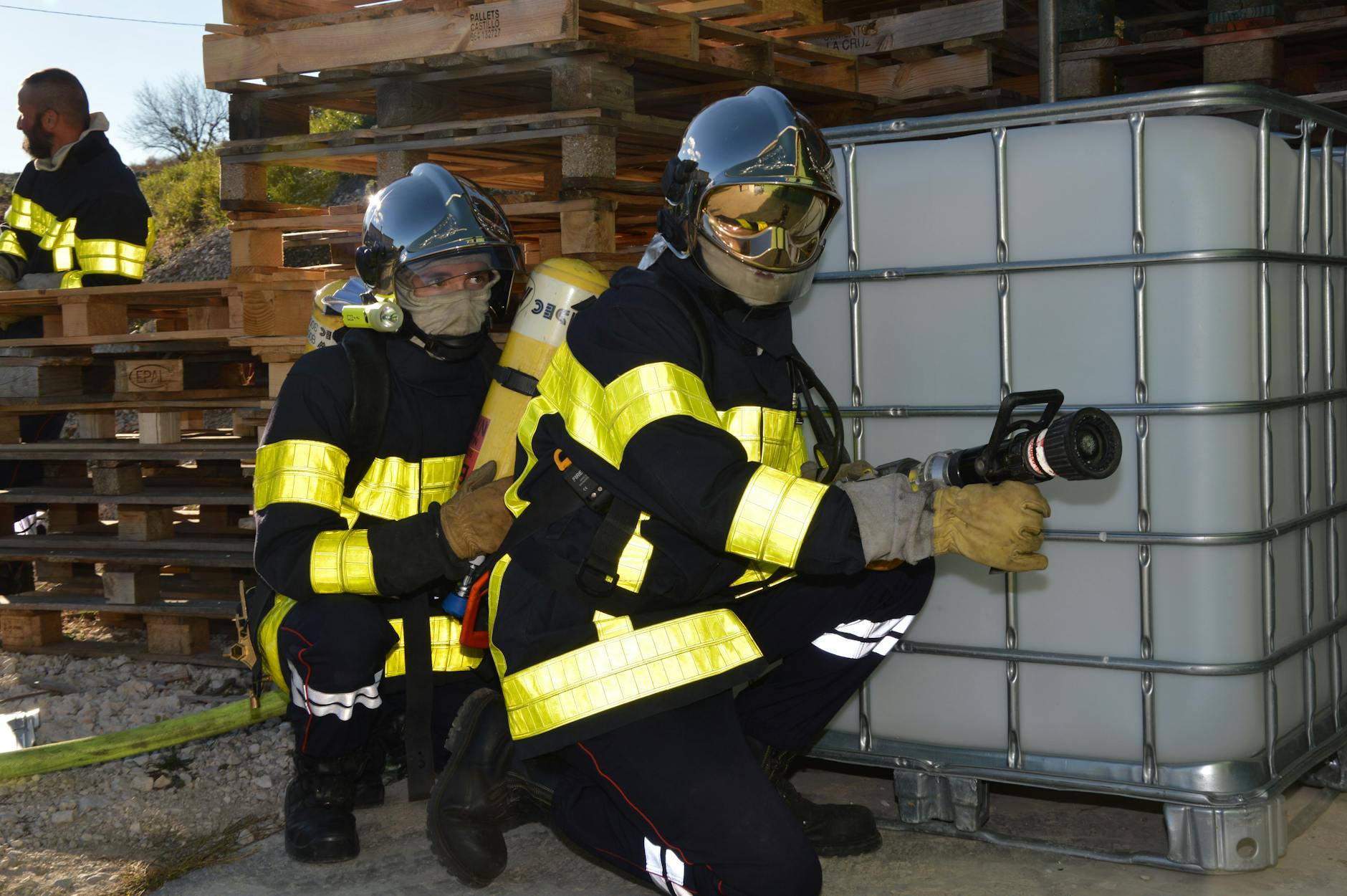 Firefighters practicing safety training with fire hoses and protective gear outdoors — UPI Study