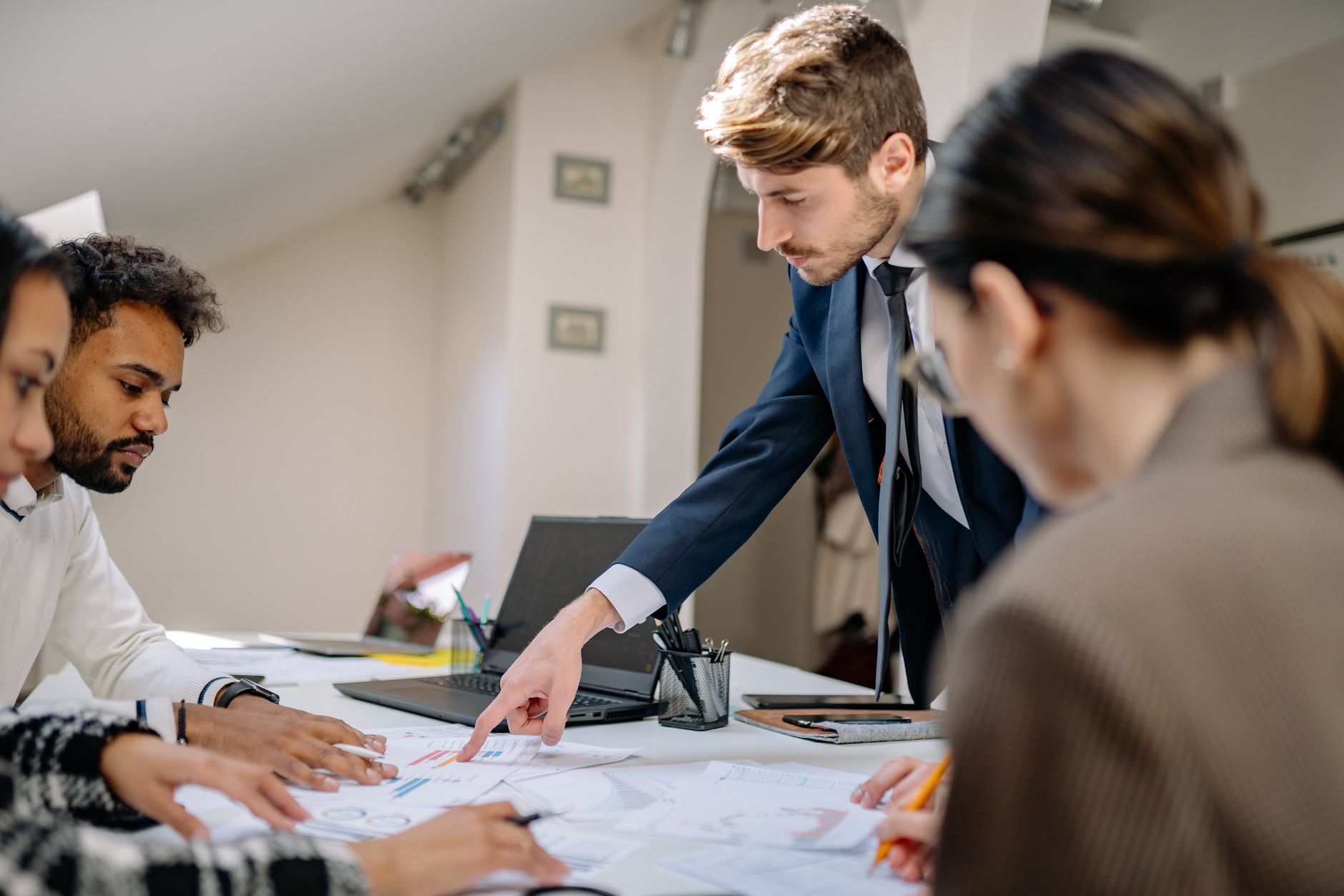 A diverse team engaged in a business meeting, fostering collaboration and teamwork in an office setting — UPI Study