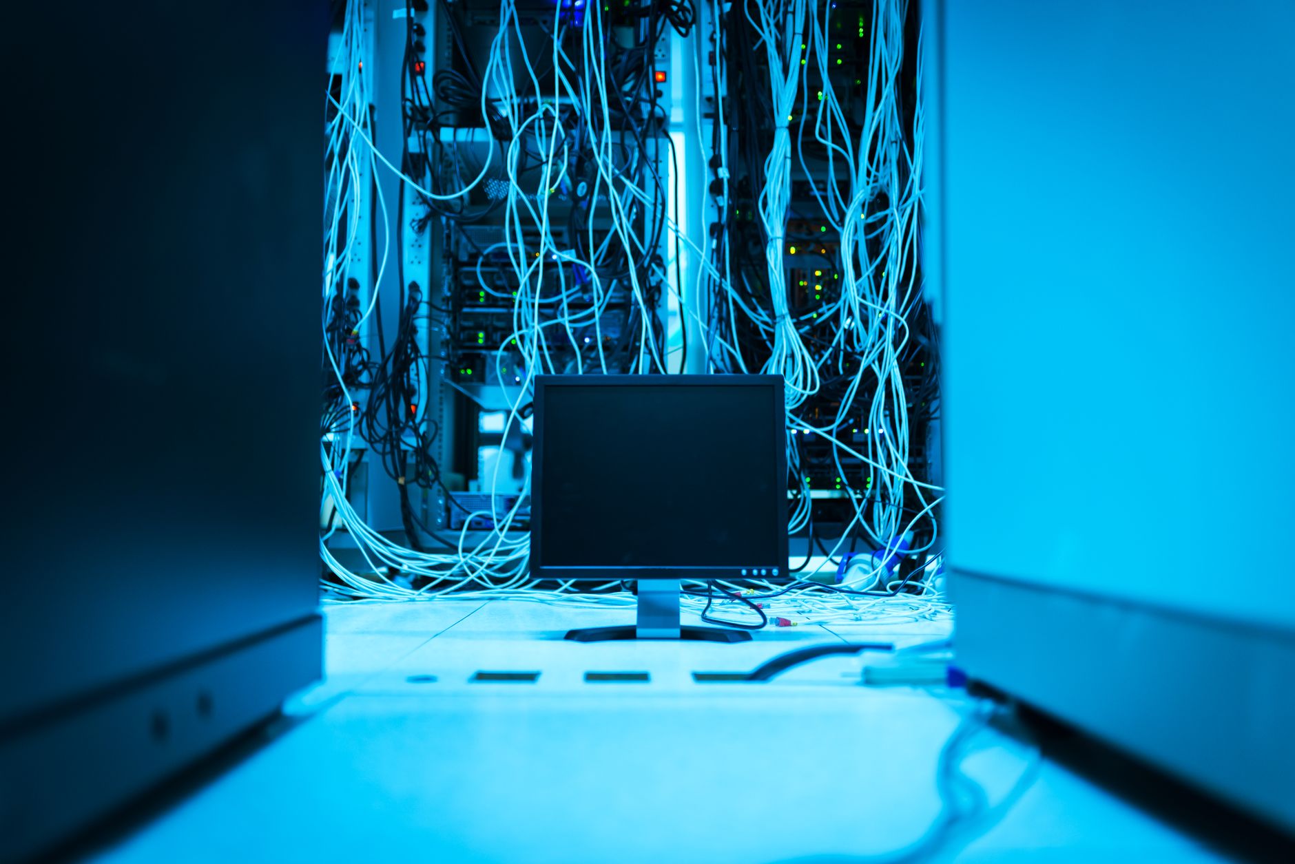 A complex network of cables in a data center with a monitor in the foreground — UPI Study