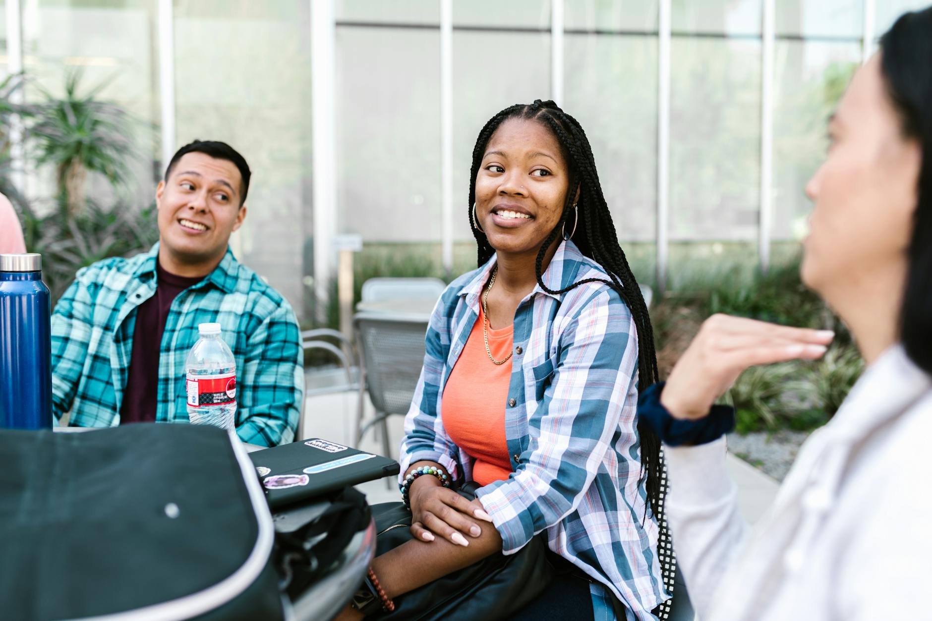 A group of diverse college students having a conversation outside in a relaxed campus setting — UPI Study