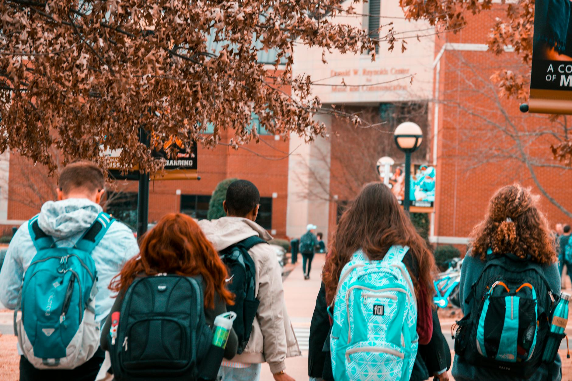 A group of college students with backpacks walking together outdoors on campus — UPI Study