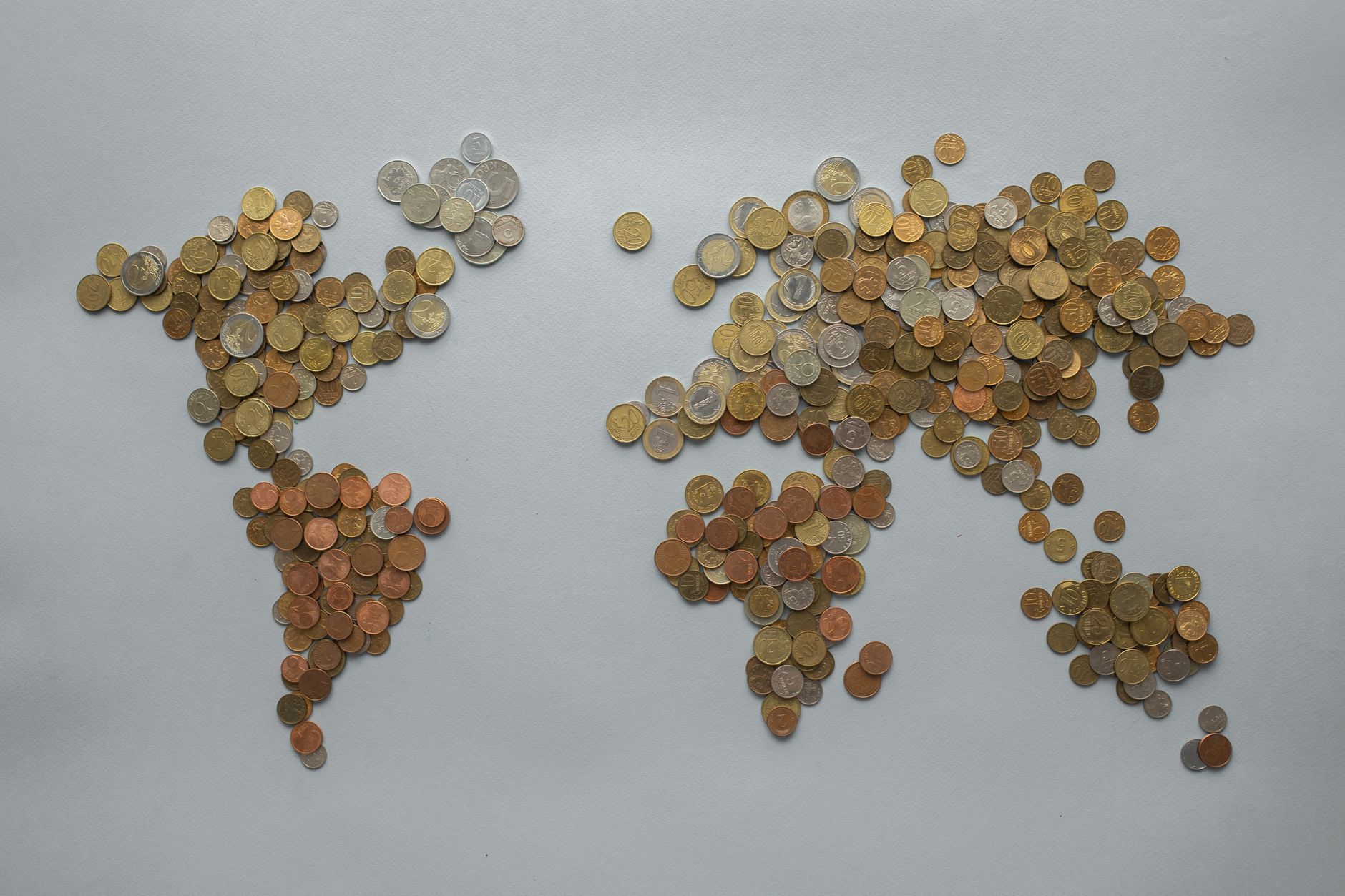 Creative world map made from assorted coins on a solid gray backdrop, symbolizing global finance — UPI Study