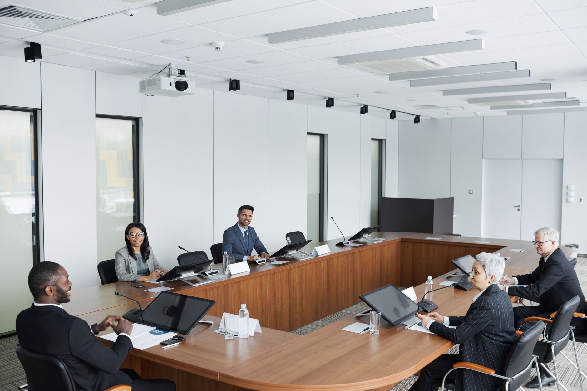 A multicultural group of professionals engaged in a business meeting in a modern conference room — UPI Study