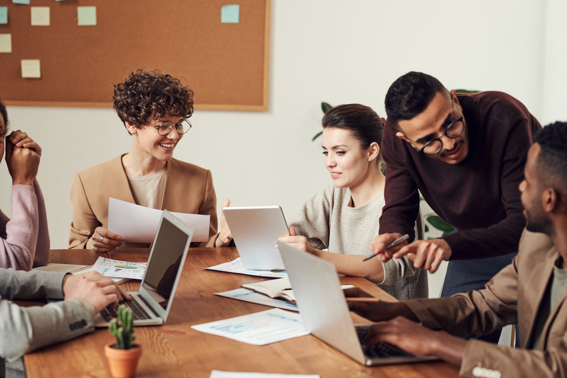 A diverse group of professionals engaged in a collaborative office meeting, sharing ideas and discussing projects — UPI Study