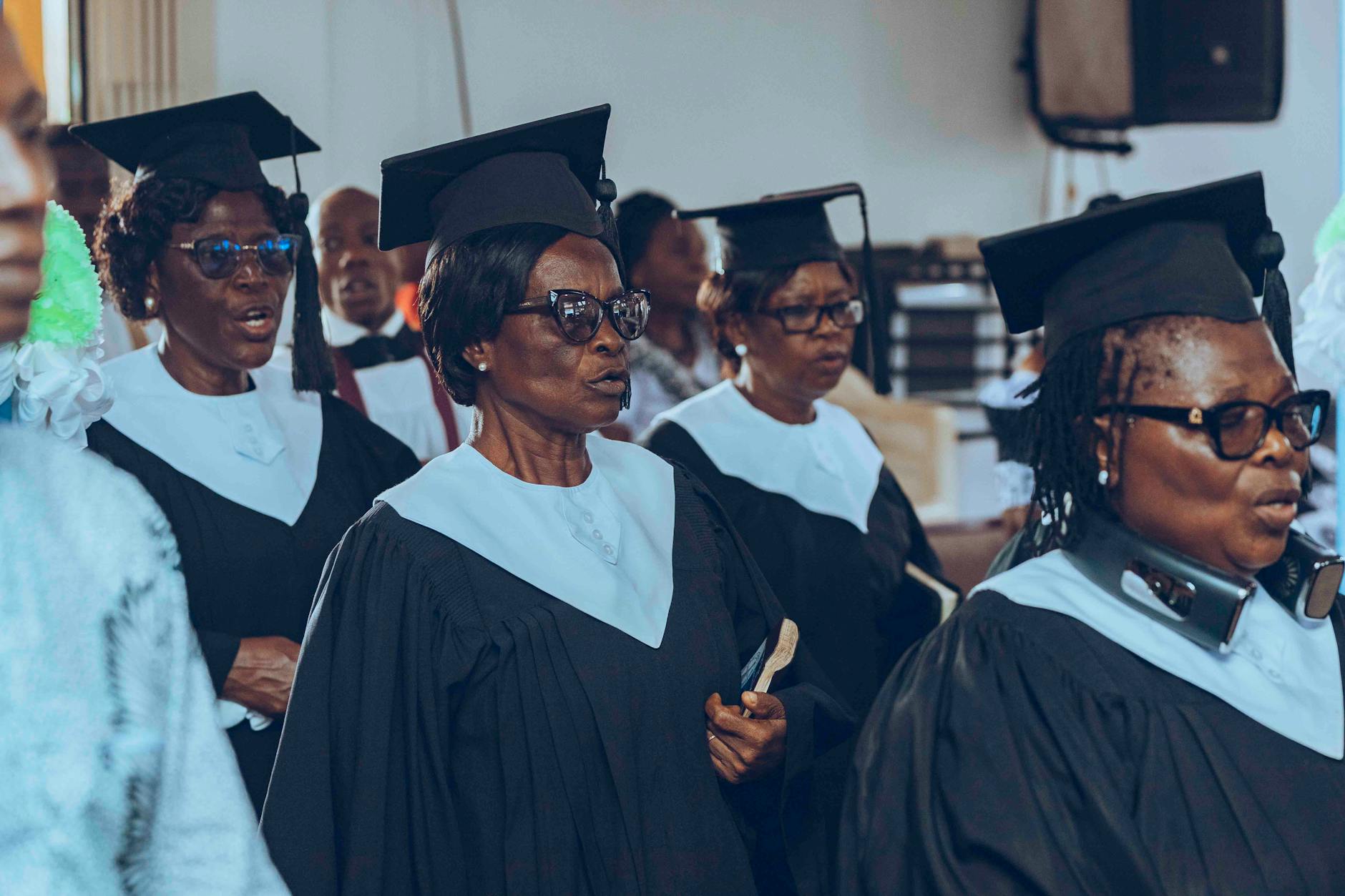 A group of senior adults wearing graduation caps and gowns at a ceremony — UPI Study