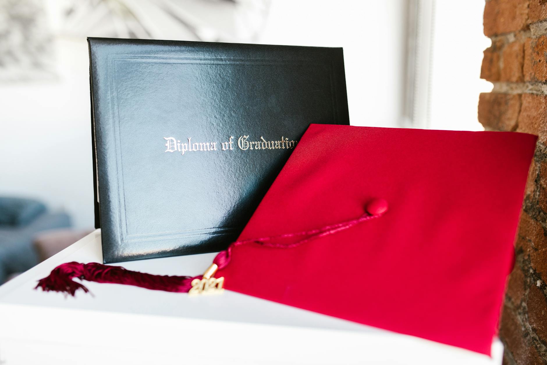Close-up of a vibrant red graduation cap and diploma, symbolizing achievement — UPI Study