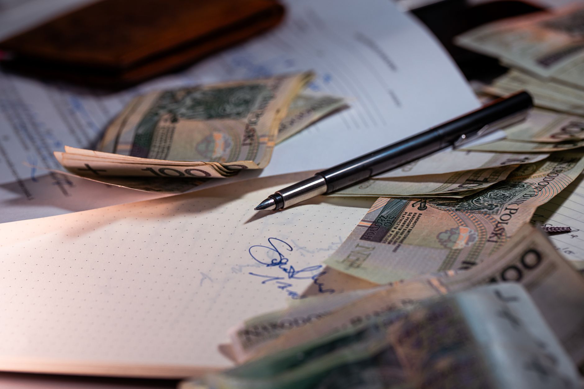 Overhead view of Polish banknotes, documents, and a pen on a desk, highlighting financial planning — UPI Study