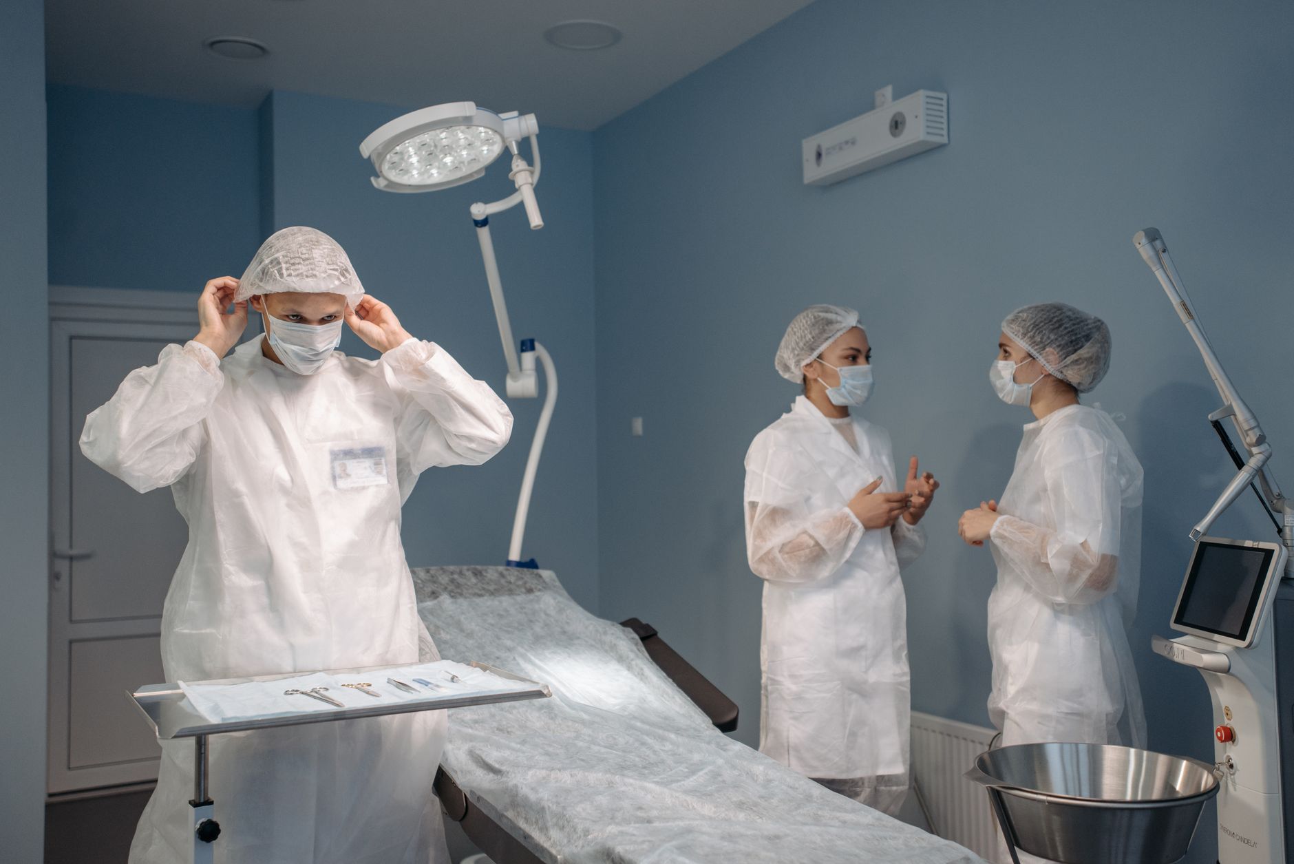 Healthcare professionals in PPE discussing surgical procedures in a modern operating room — UPI Study