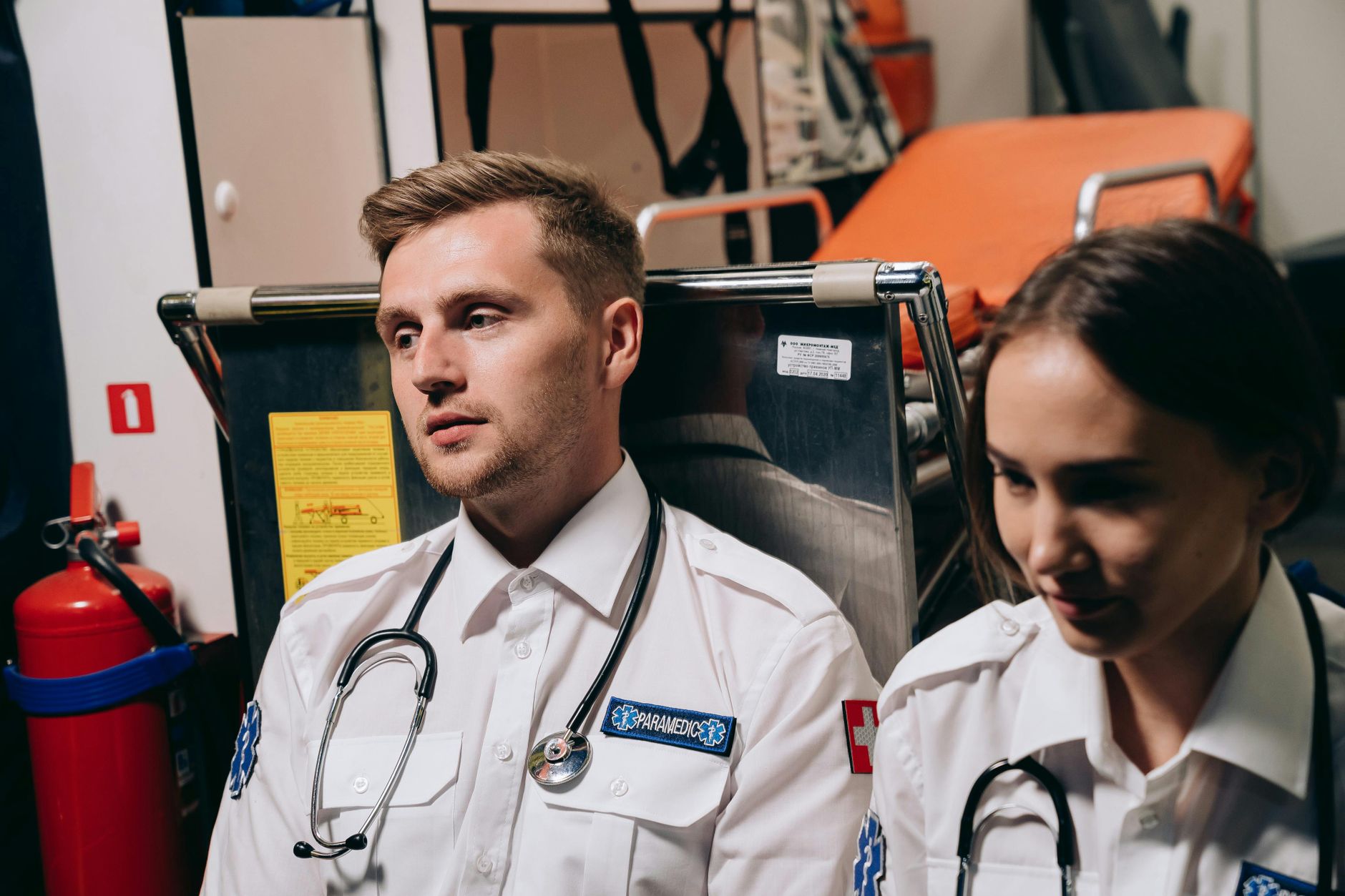 Two paramedics sitting in an ambulance, equipped with stethoscopes and emergency tools — UPI Study