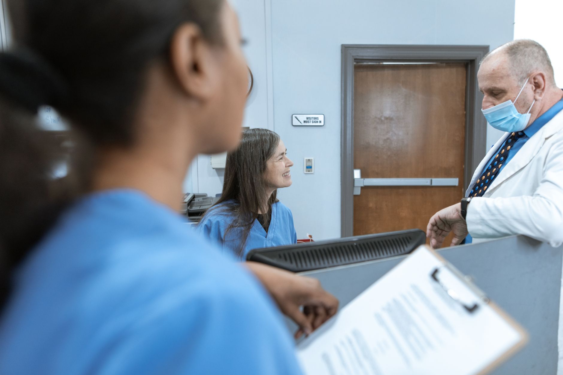 Healthcare professionals in discussion at a hospital reception, emphasizing teamwork and communication — UPI Study