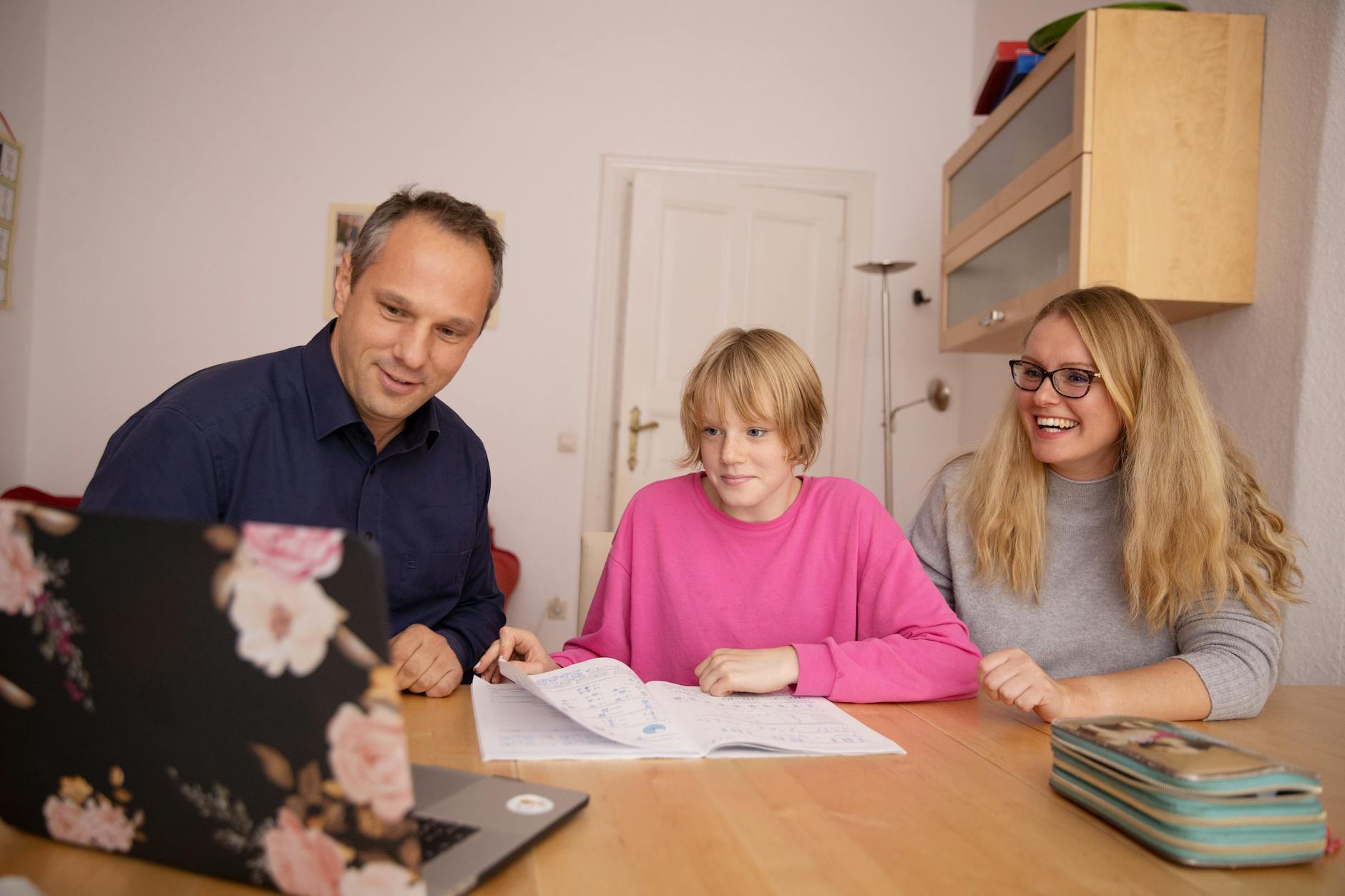 Family engaged in online learning together at home using laptop, focusing on education and connection — UPI Study