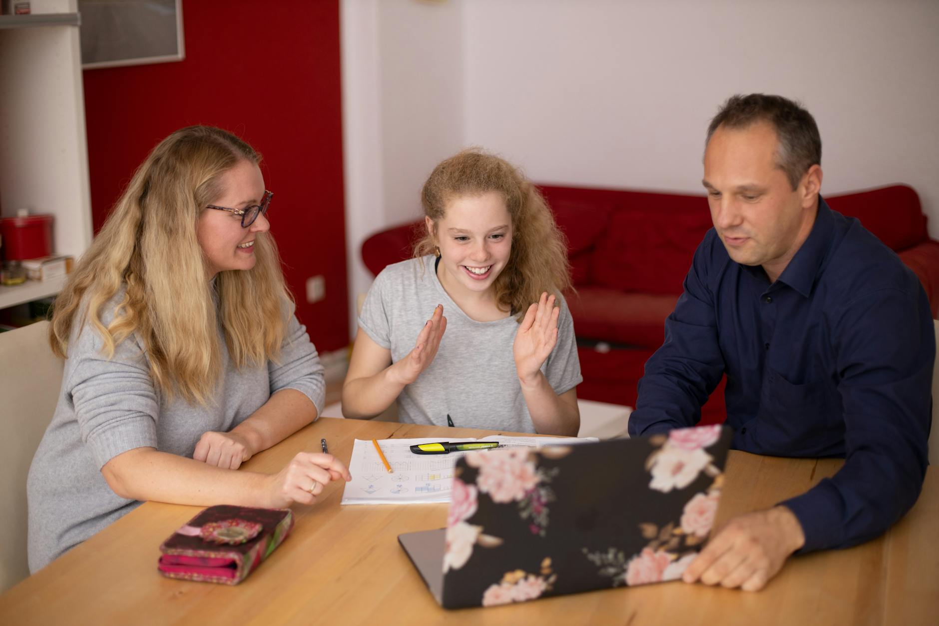 A family happily engaged in remote learning at home using a laptop. Educational collaboration — UPI Study