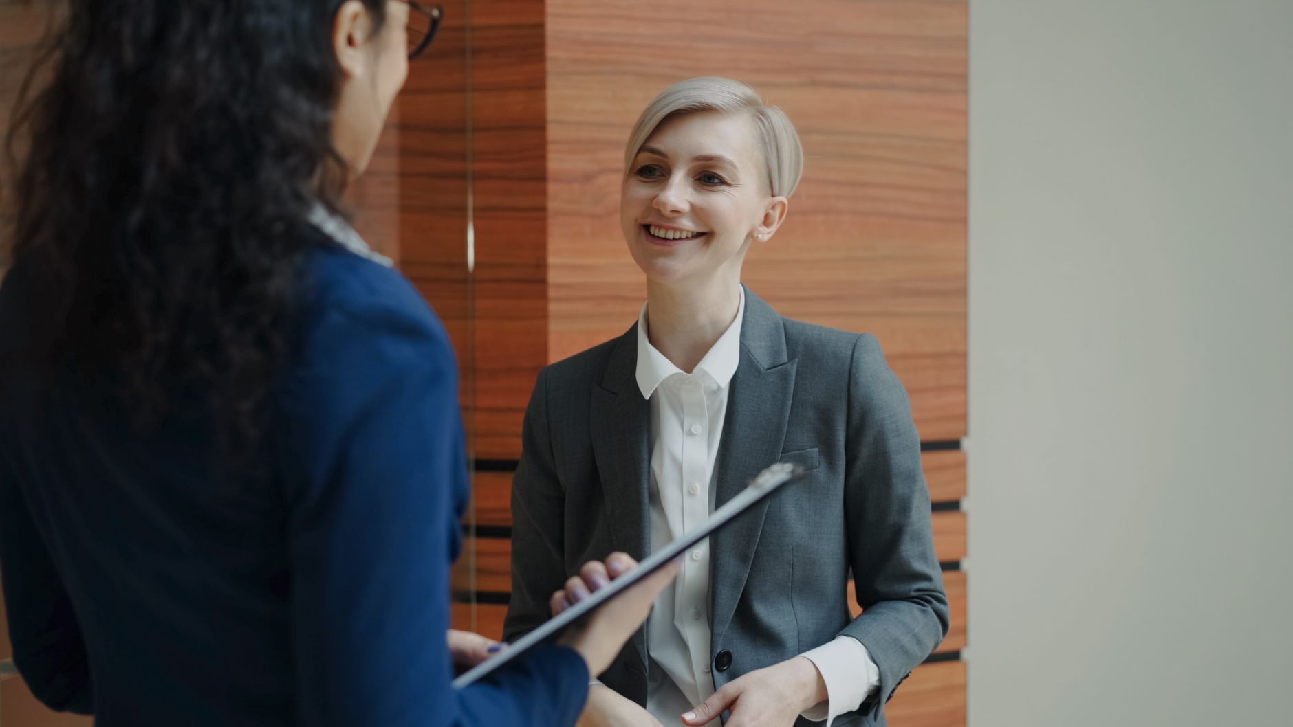 Two professionals having a conversation during a business meeting indoors — UPI Study