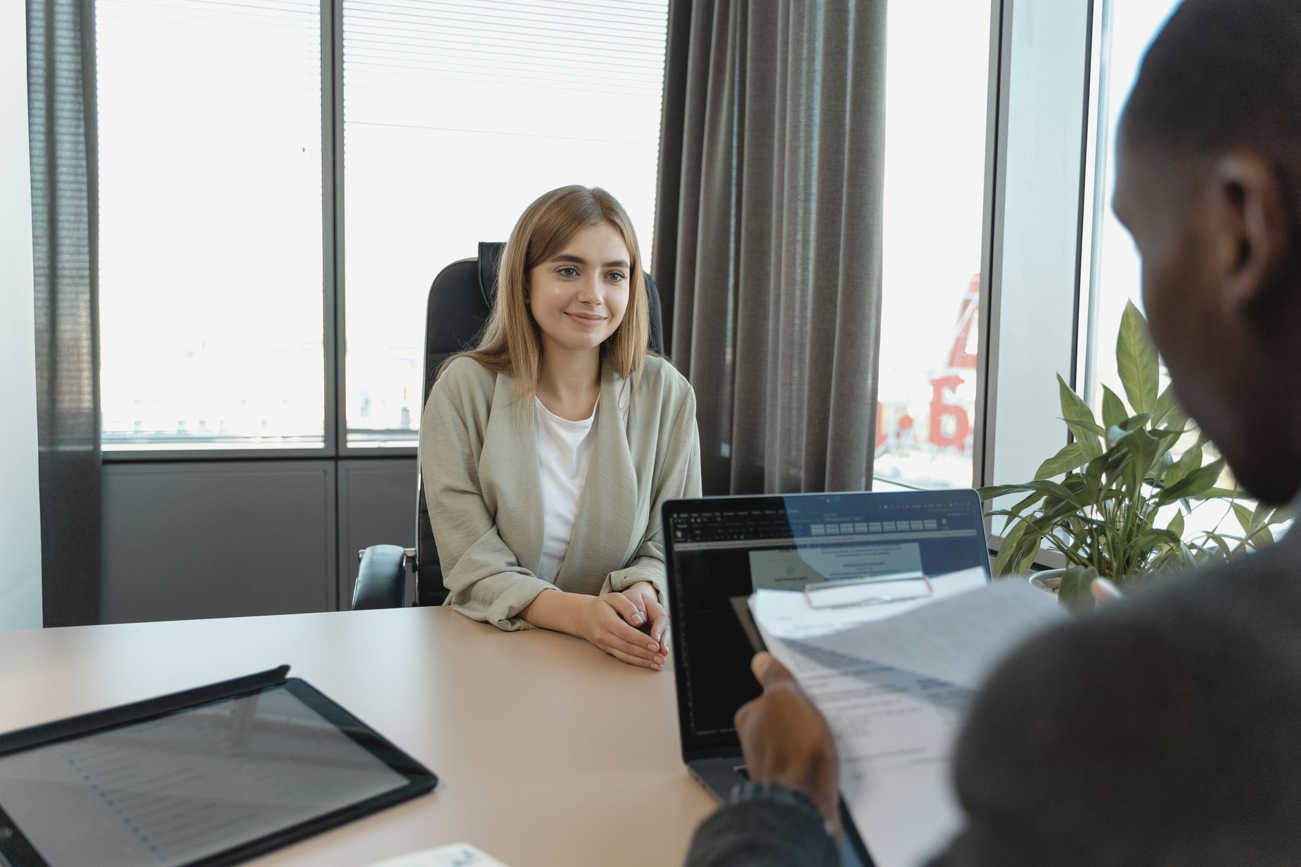 Young woman sitting confidently in a modern office for a job interview — UPI Study