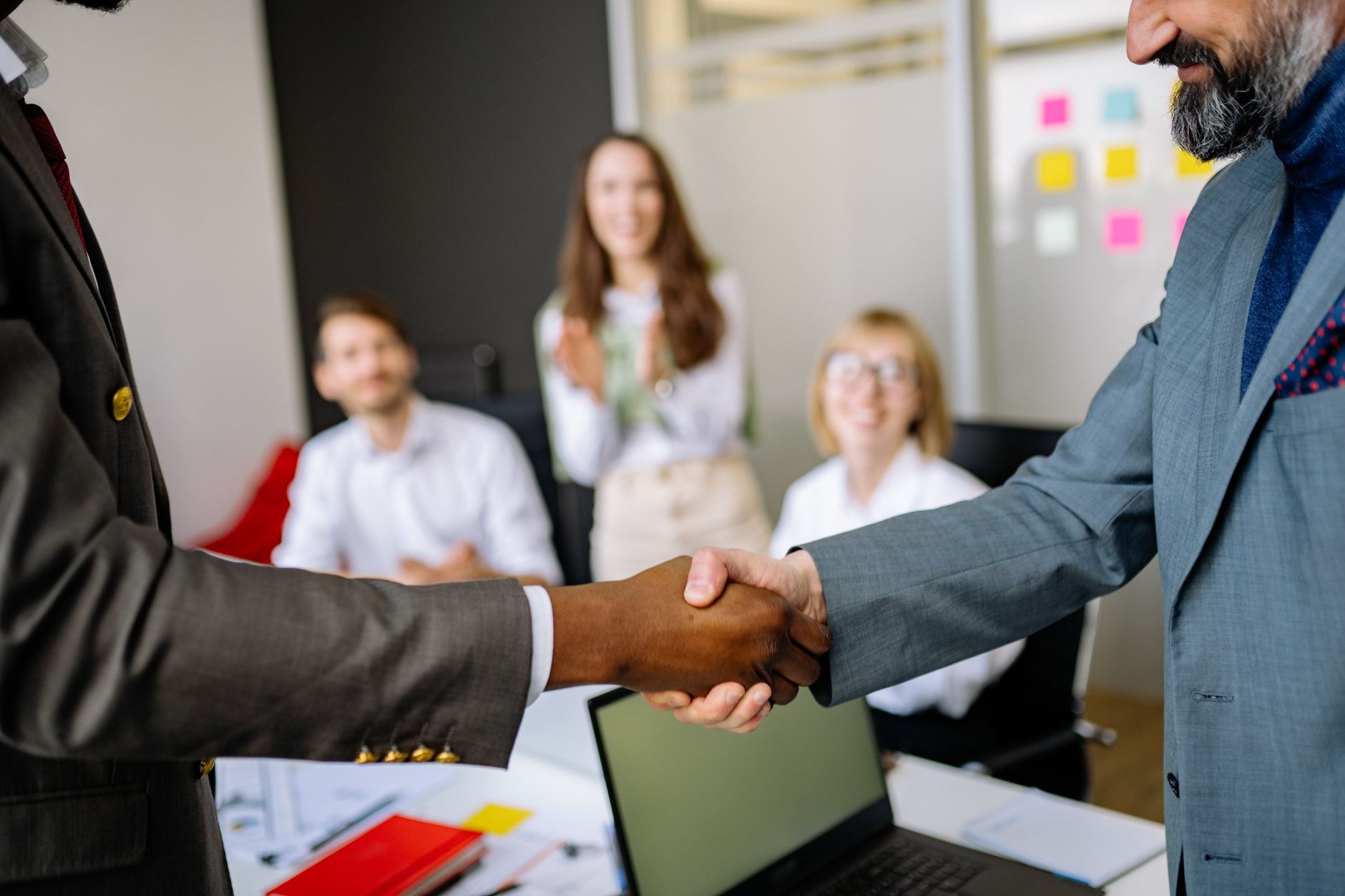 Close-up of a handshake between colleagues in a professional office setting, emphasizing teamwork and agreement — UPI Study