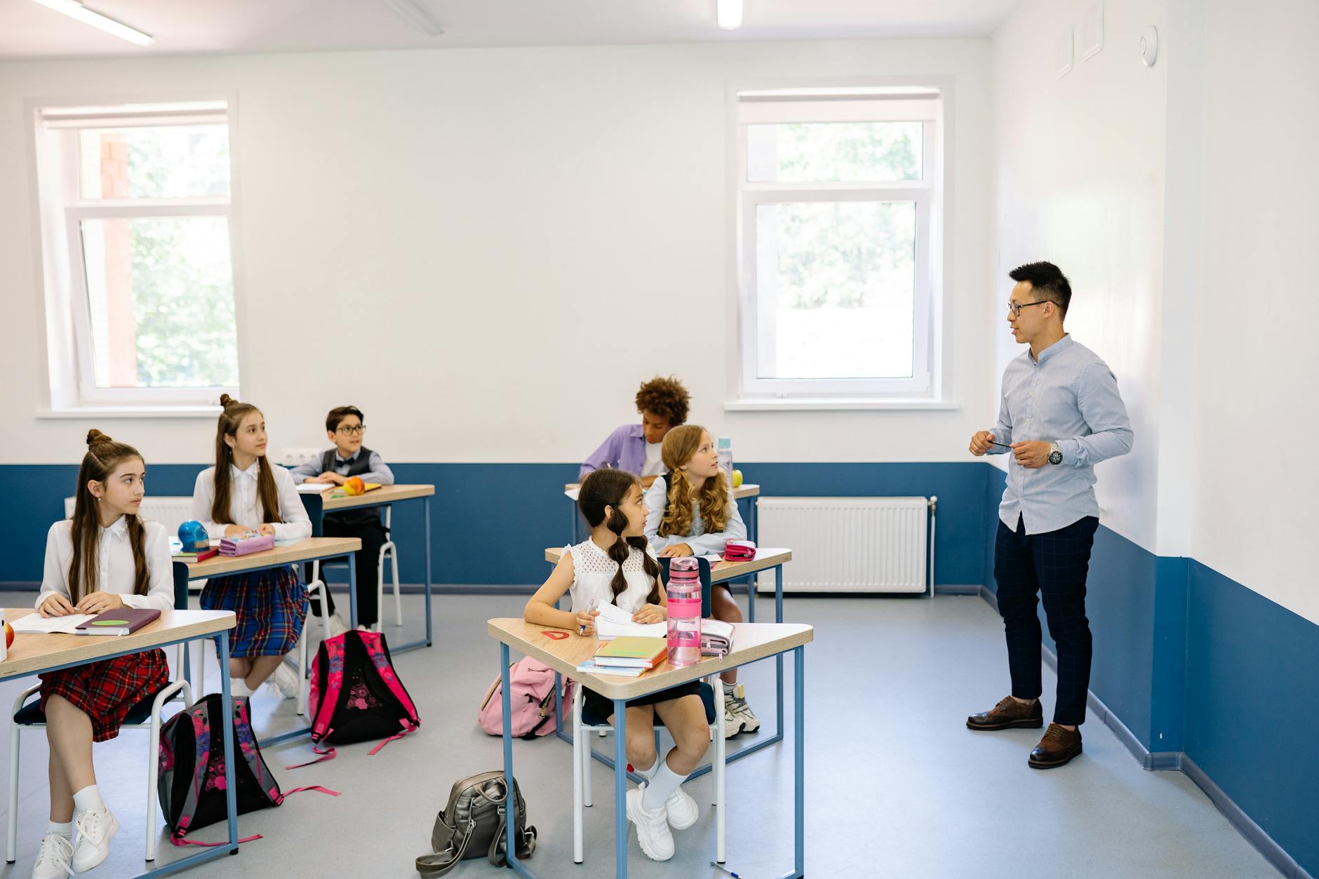 Students attentively listening to a teacher during a classroom lesson — UPI Study