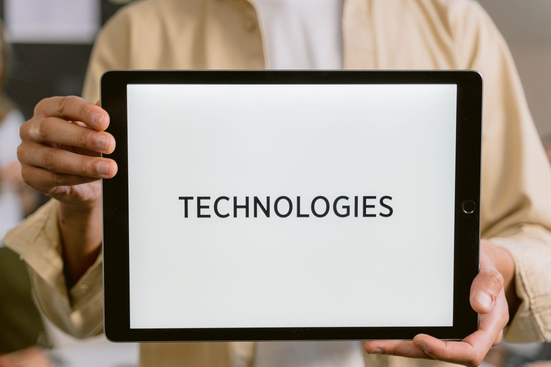 Close-up of a person holding a tablet with the word 'Technologies' on the screen — UPI Study