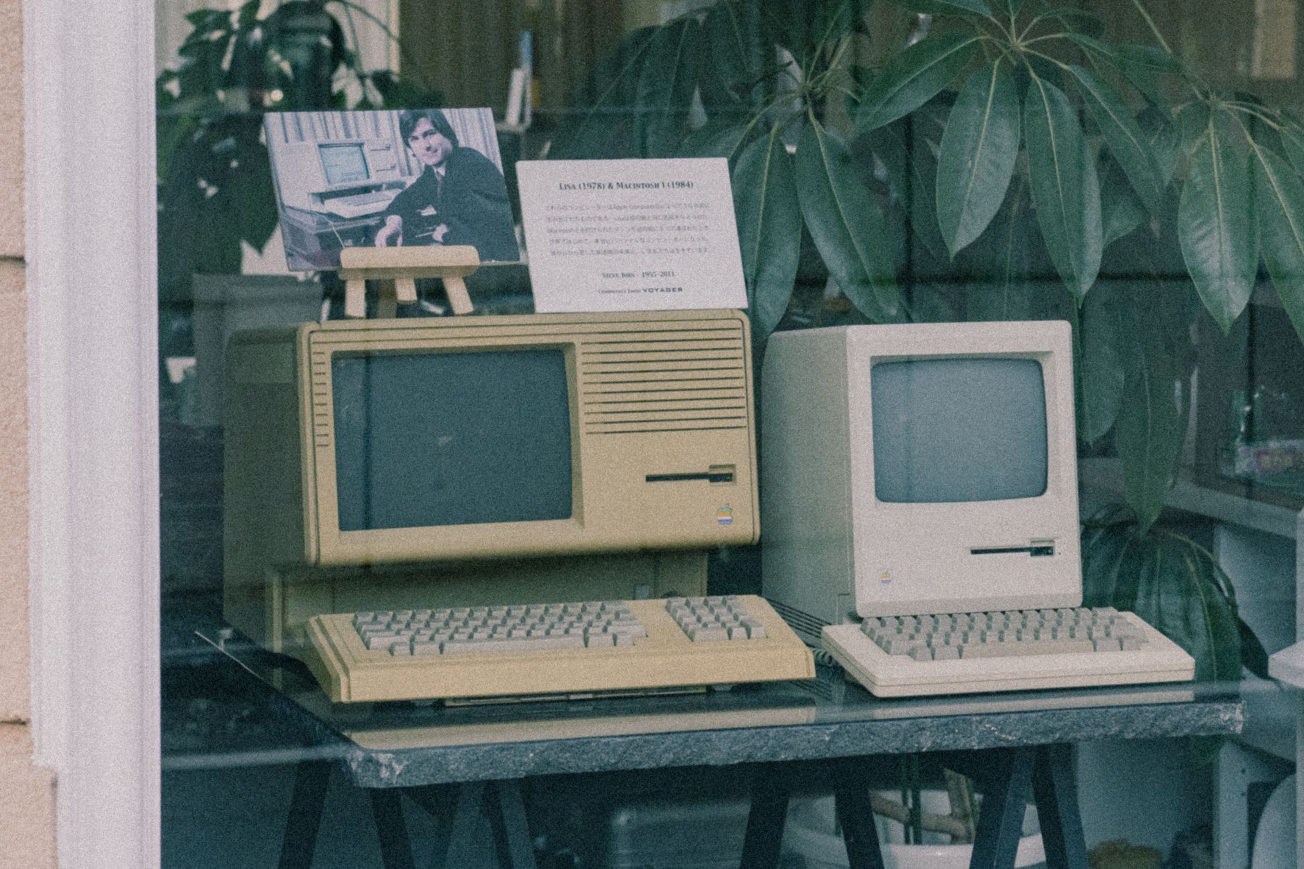 Retro Apple computers with keyboards displayed in a Tokyo store window, showcasing early tech design — UPI Study