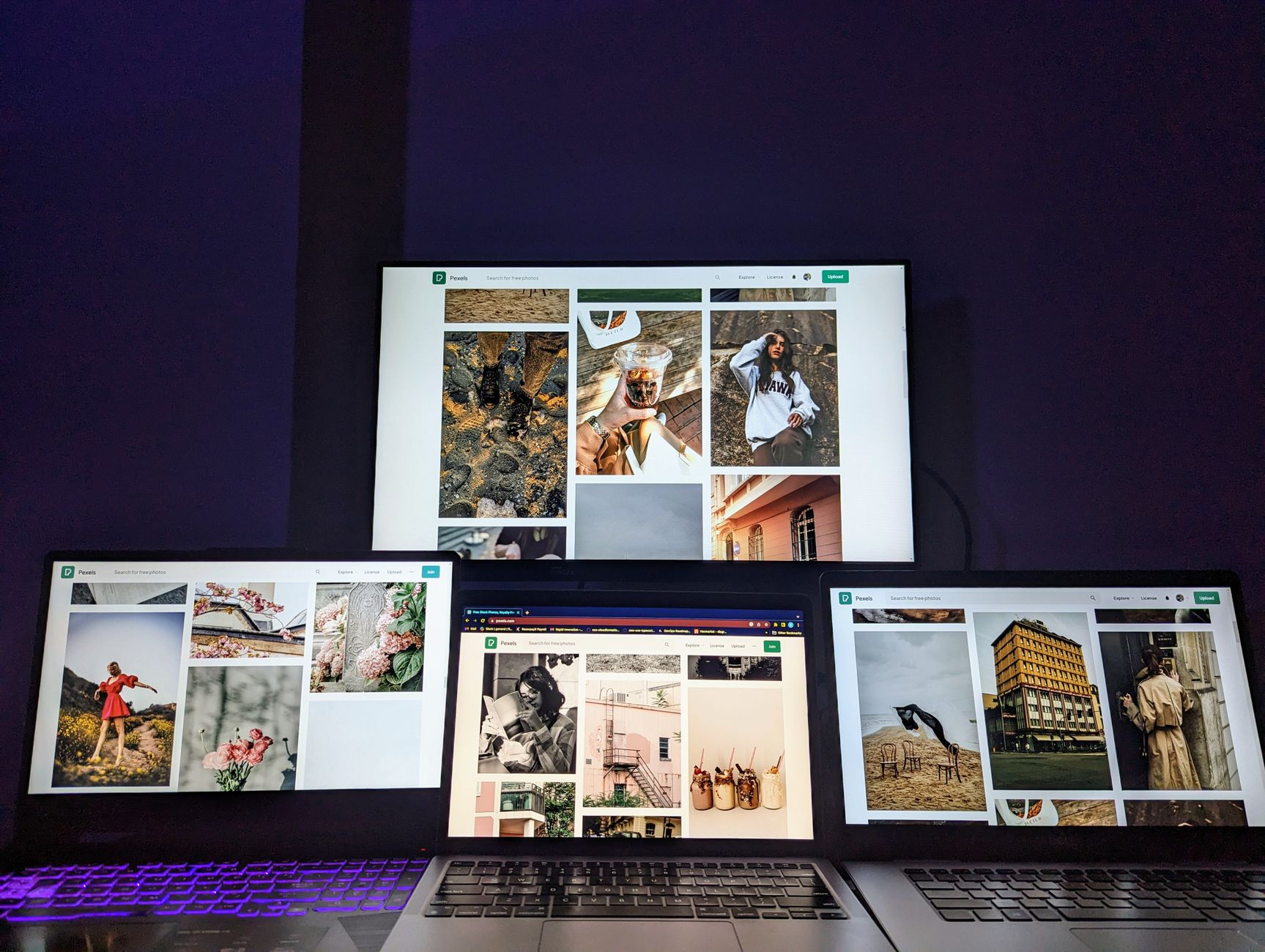 A high-tech workspace featuring three laptops and a monitor with various images displayed, highlighting technology and digital art — UPI Study