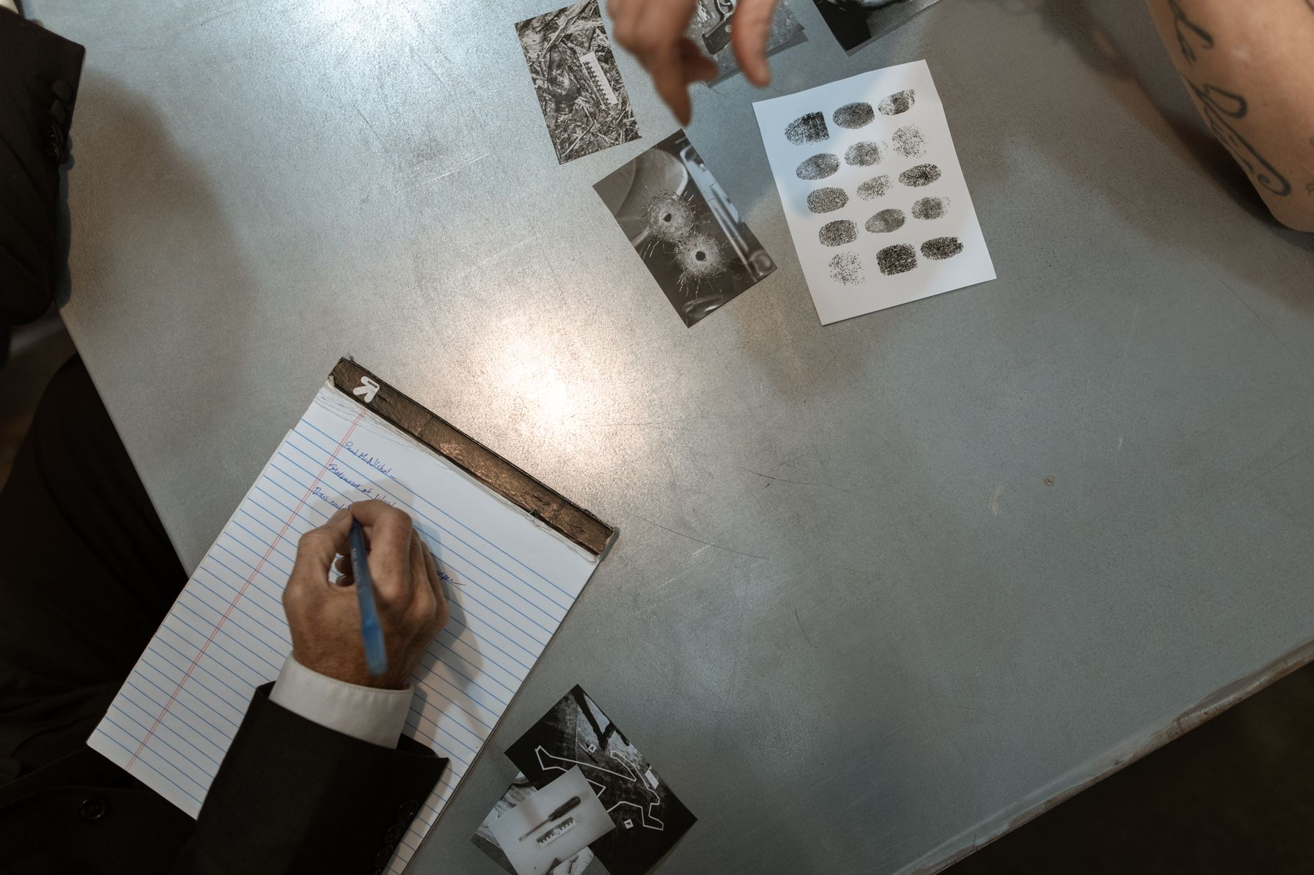 Officers at work reviewing evidence and taking notes in an investigation setting — UPI Study