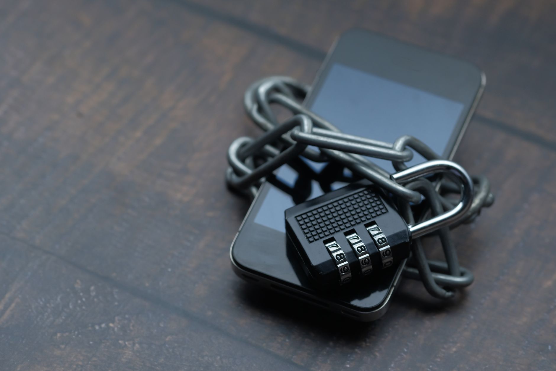 Close-up of a smartphone wrapped in a chain with a padlock, symbolizing strong security — UPI Study
