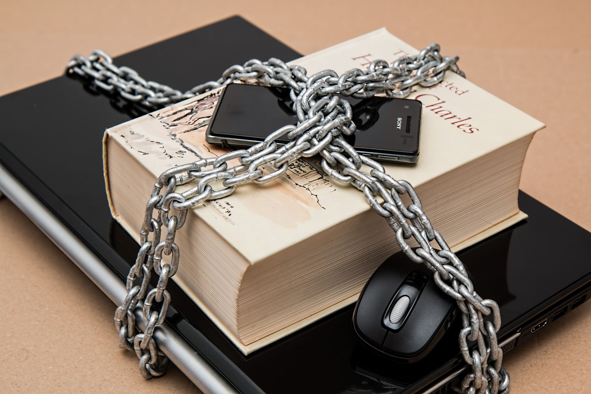 Chain-locked book, phone, and laptop symbolizing digital and intellectual security — UPI Study
