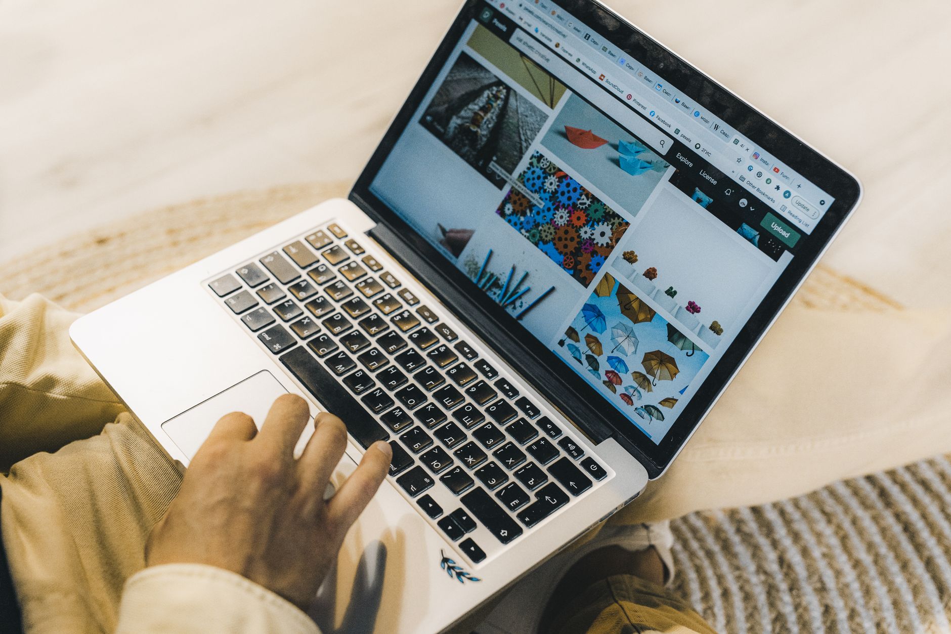 A person using a laptop to browse stock photo websites. Freelancing work in a cozy setting — UPI Study
