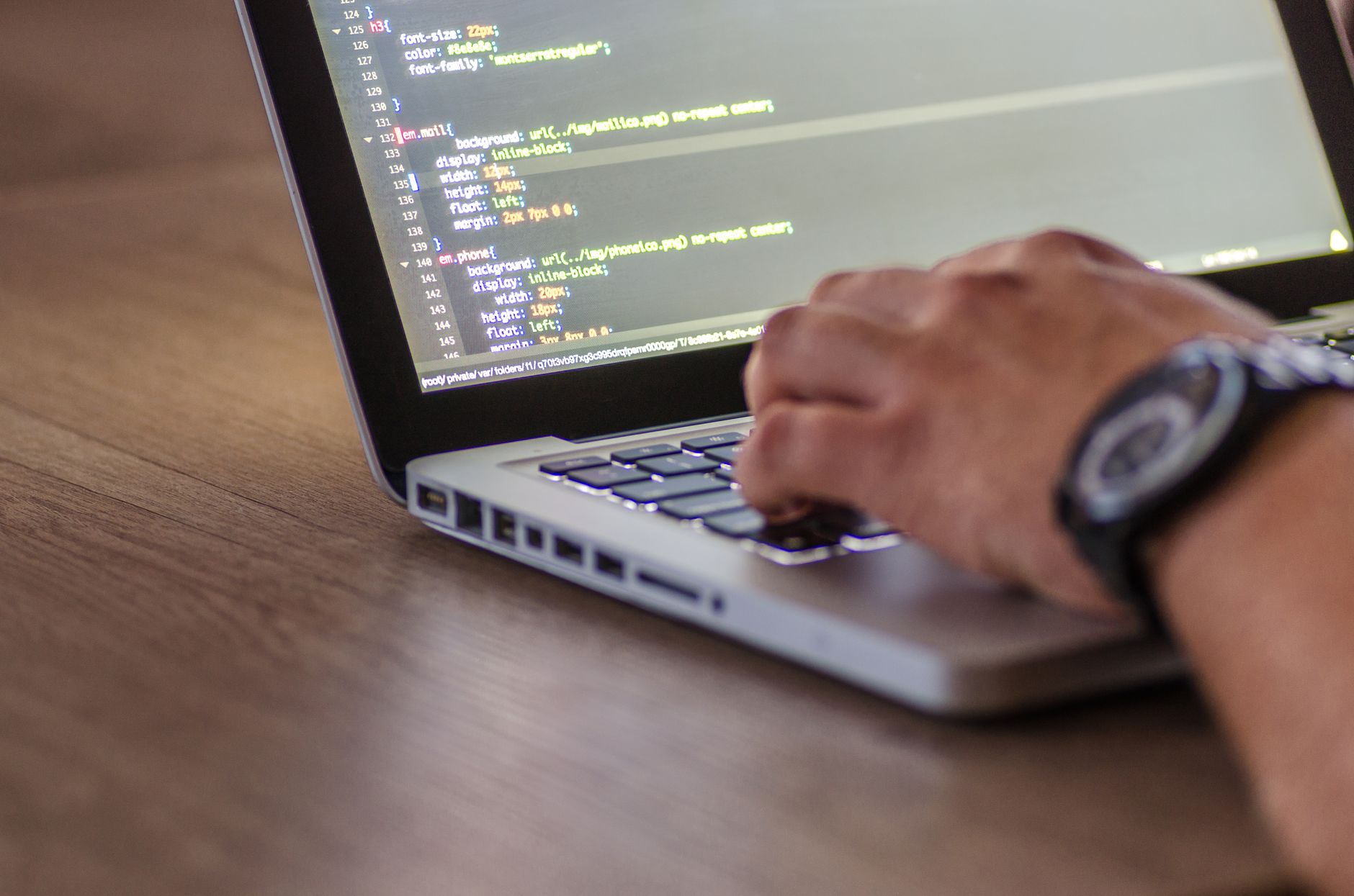 A close-up shot of a person coding on a laptop, focusing on the hands and screen — UPI Study