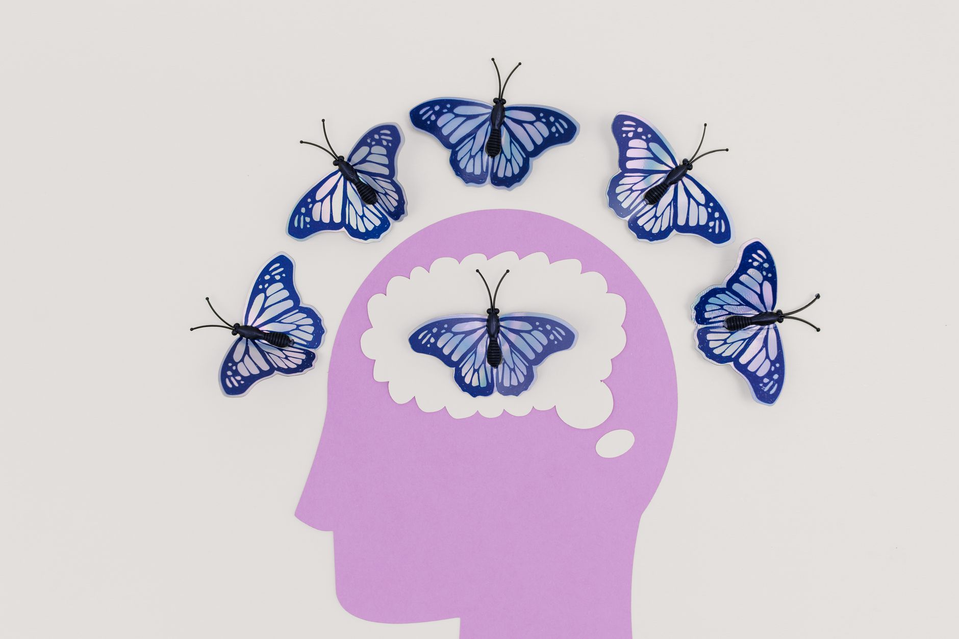 Creative illustration of butterflies representing thoughts over a brain silhouette — UPI Study
