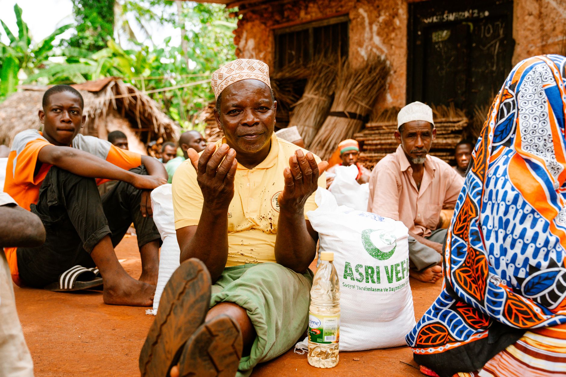 A group of people in a rural setting engaged in communal activities and conversation — UPI Study