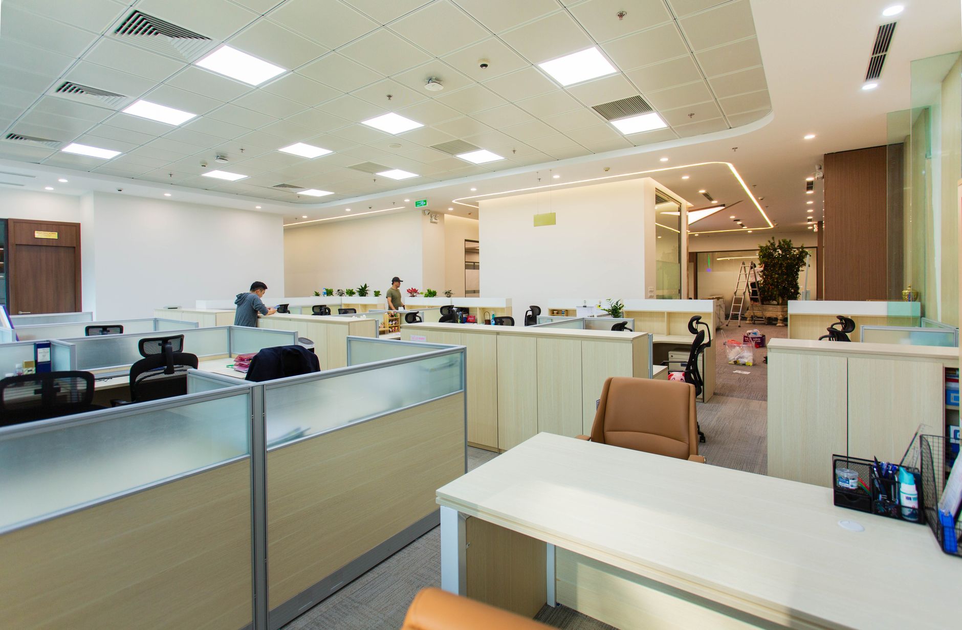 Bright and spacious office interior featuring open-plan cubicles, modern furniture, and ceiling lights — UPI Study