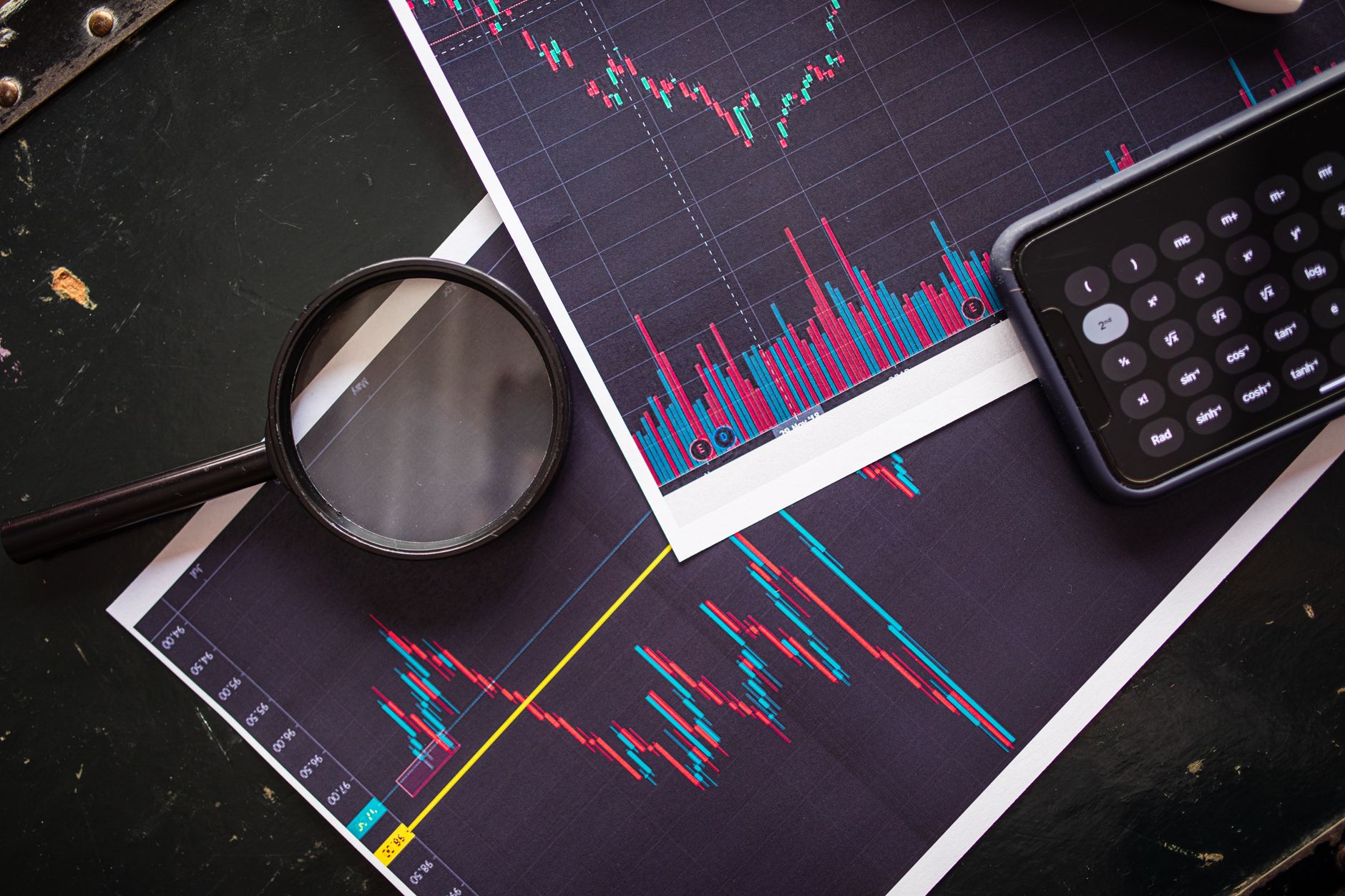 Stock market charts analyzed with a magnifying glass and calculator for financial research — UPI Study