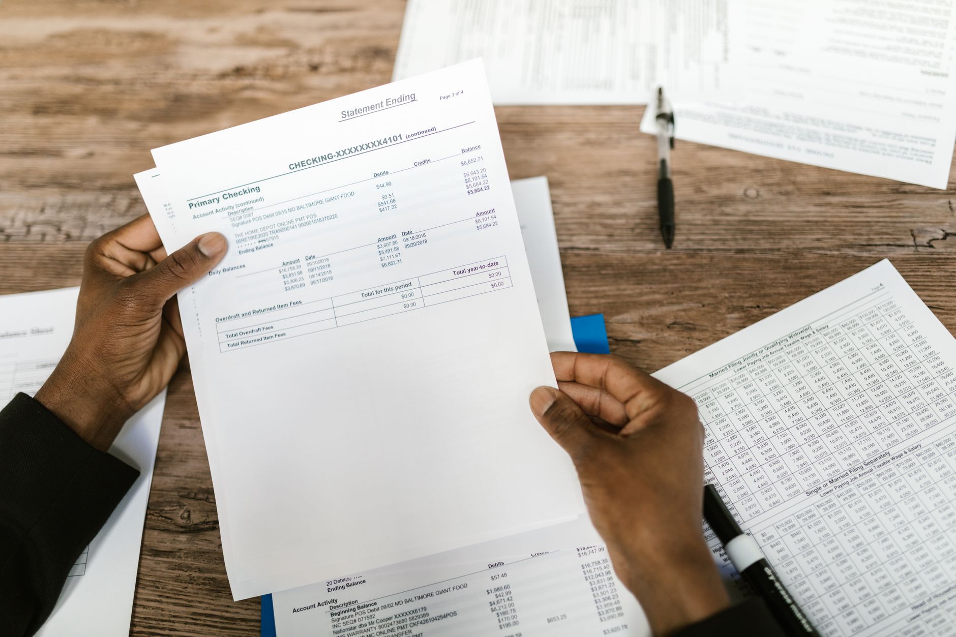 Hands holding financial papers for tax preparation and analysis — UPI Study