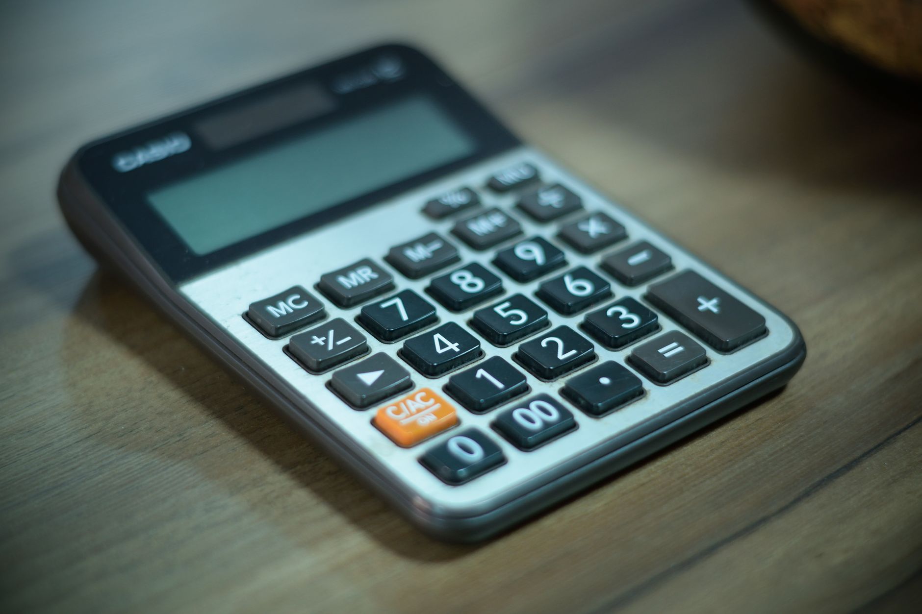 Digital calculator resting on a wooden table, selective focus — UPI Study