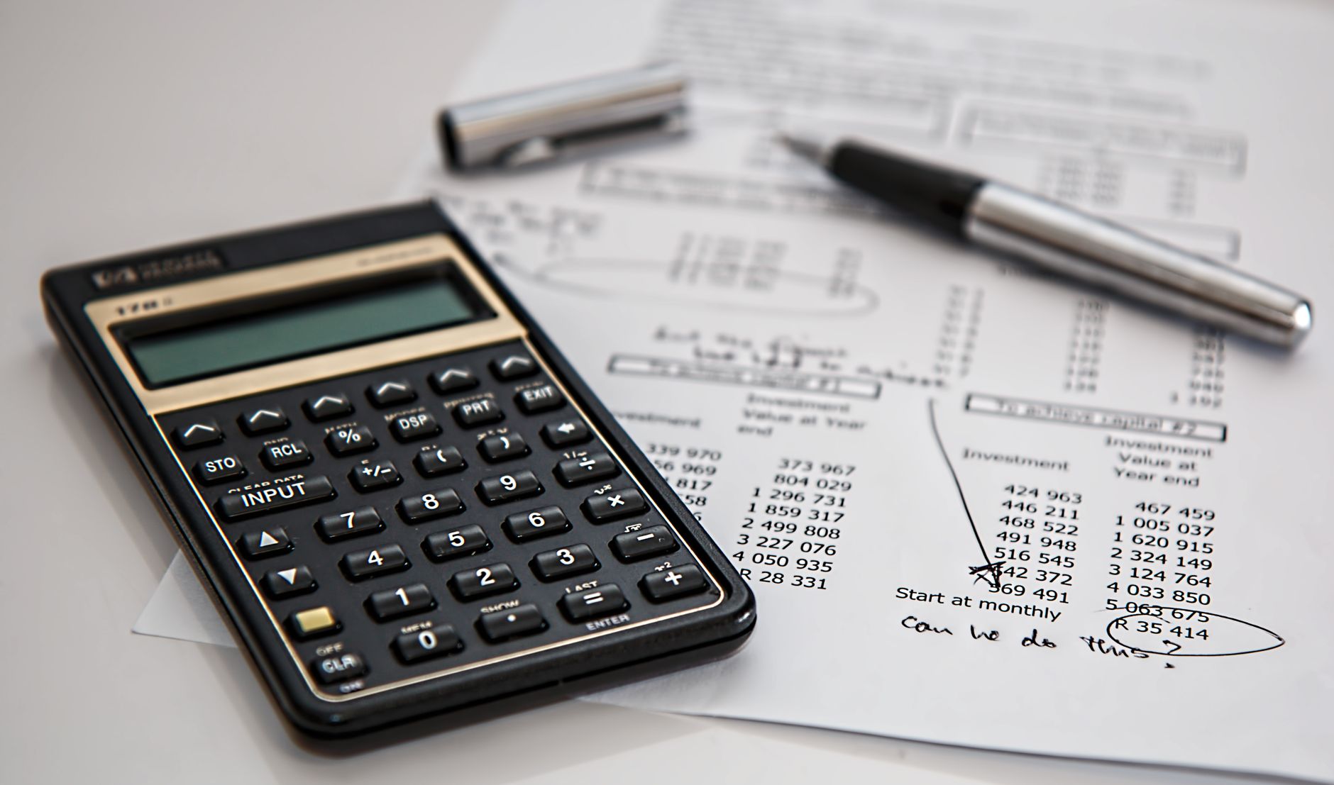 Close-up of financial documents with calculator and pen, ideal for business management themes — UPI Study