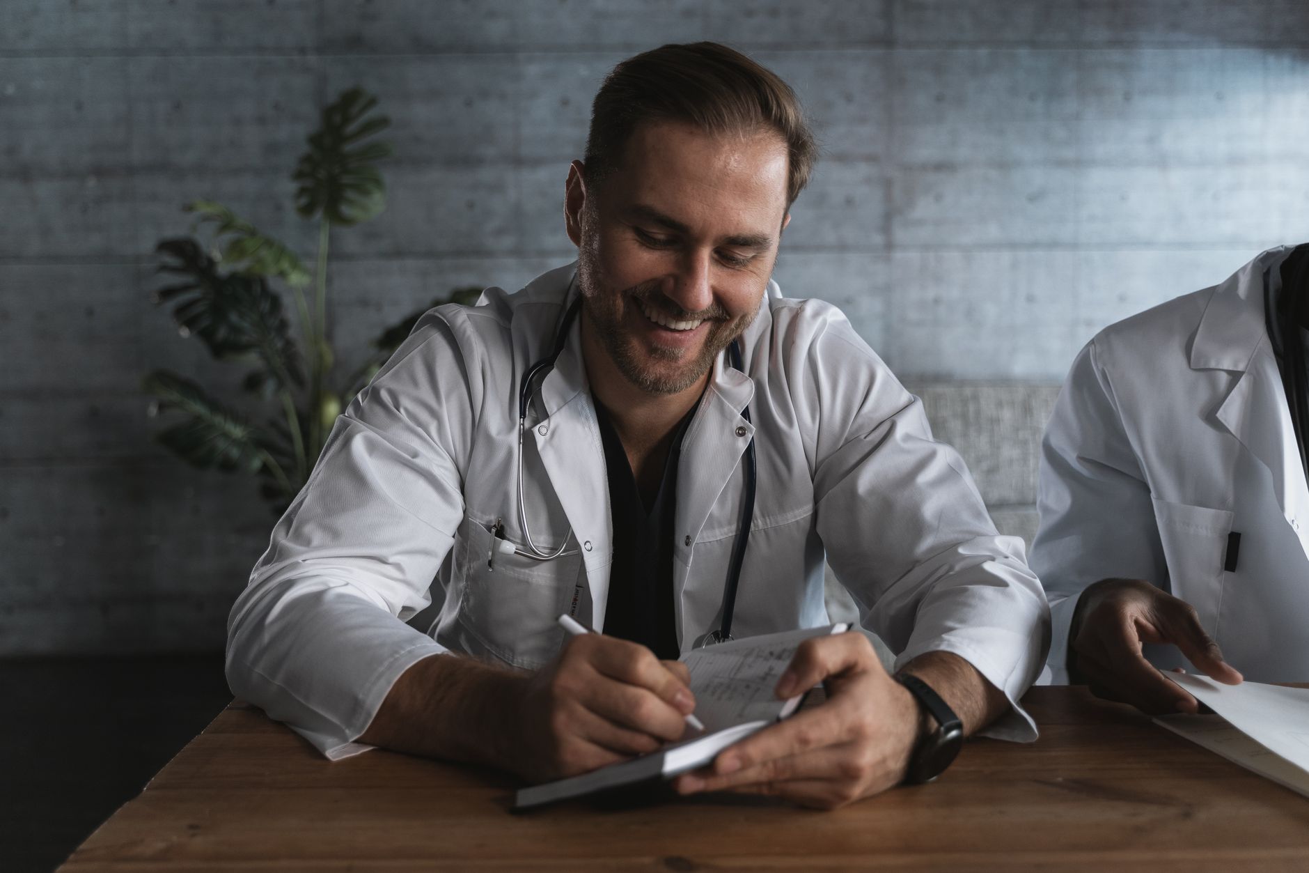 A smiling doctor taking notes in a medical office setting — UPI Study