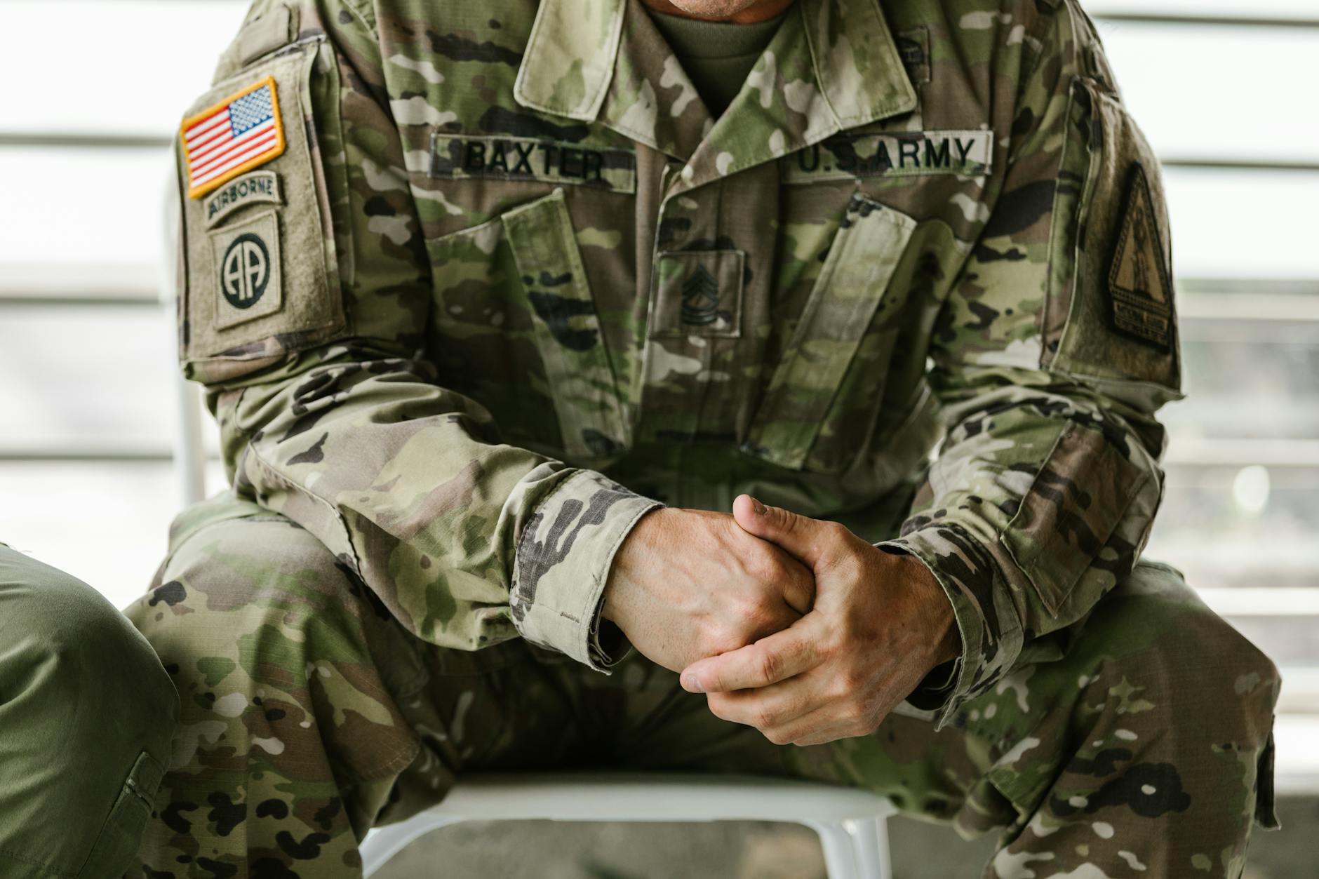 Close-up image of a soldier wearing a camouflage military uniform, displaying patches and insignia — UPI Study