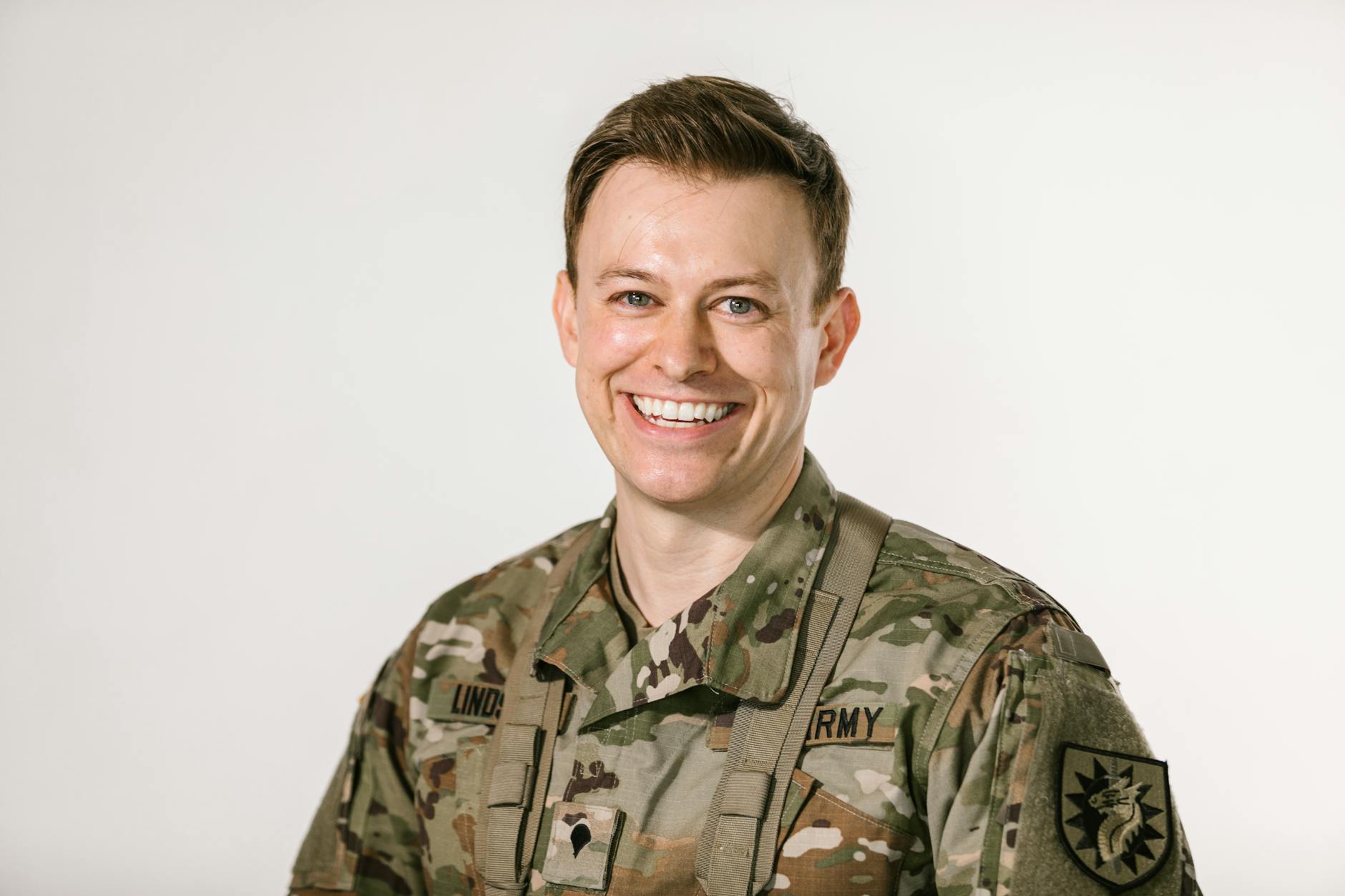 Portrait of a smiling US Army soldier in camouflage uniform on a white background — UPI Study