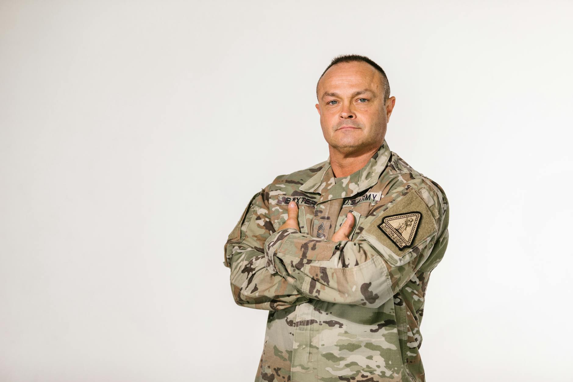 Military veteran standing with pride in camouflage uniform against a white background — UPI Study