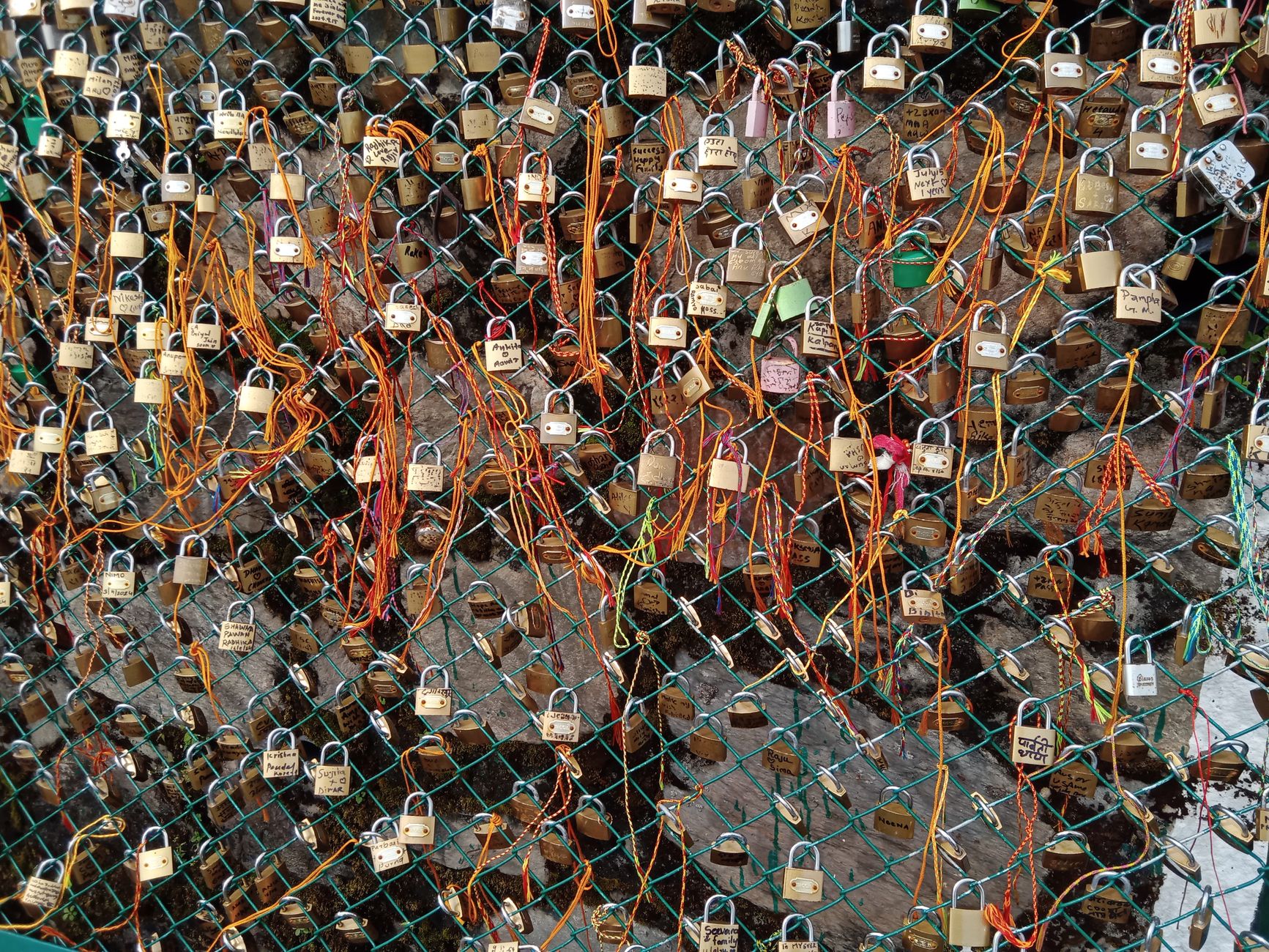 A vibrant display of love locks attached to a fence with colorful ribbons — UPI Study