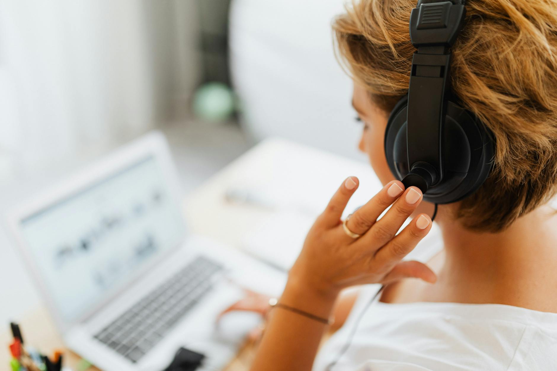 Woman at home using headphones and laptop for online work or video call — UPI Study