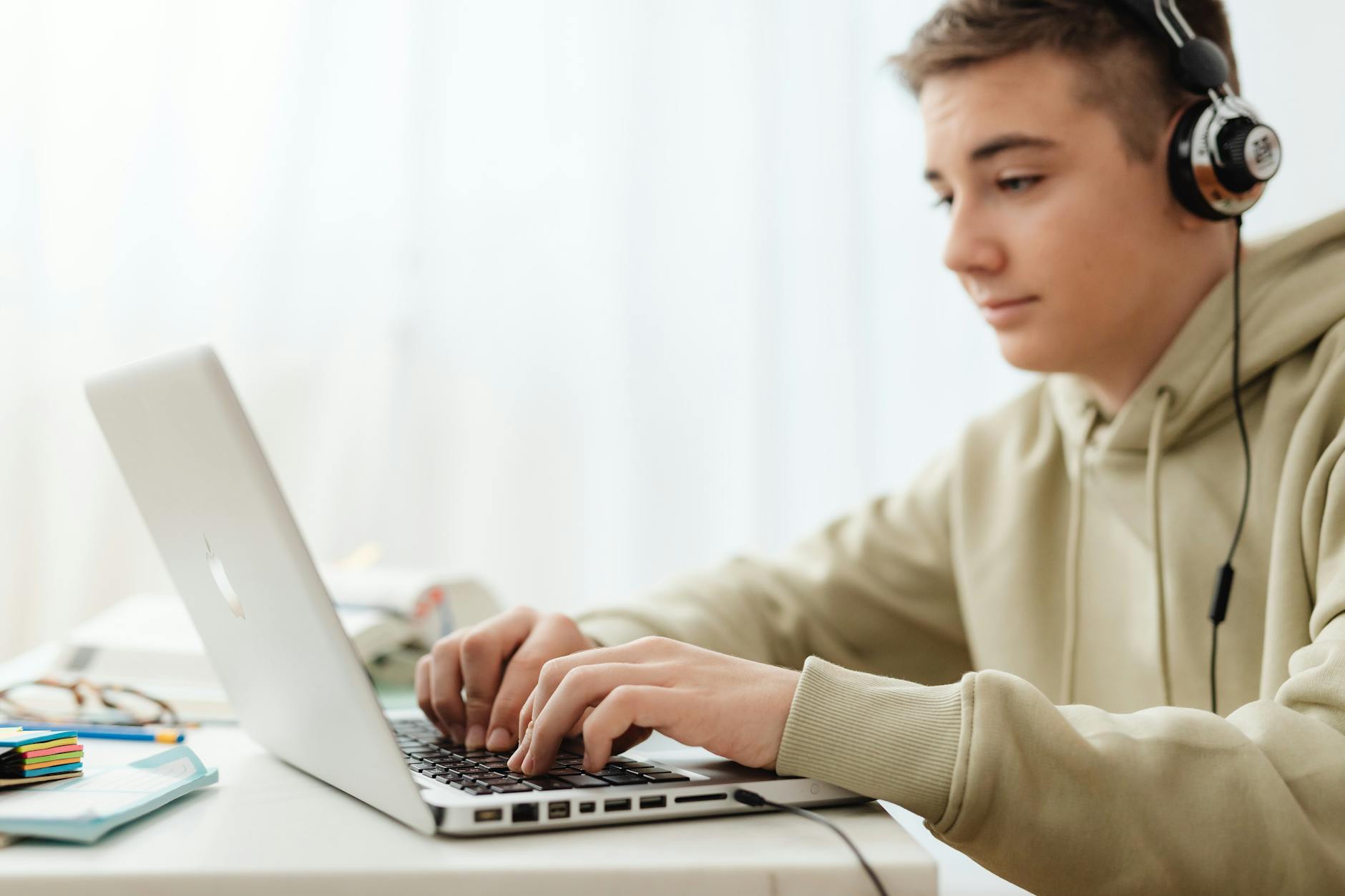 Teen using a laptop and headphones for online learning at home — UPI Study