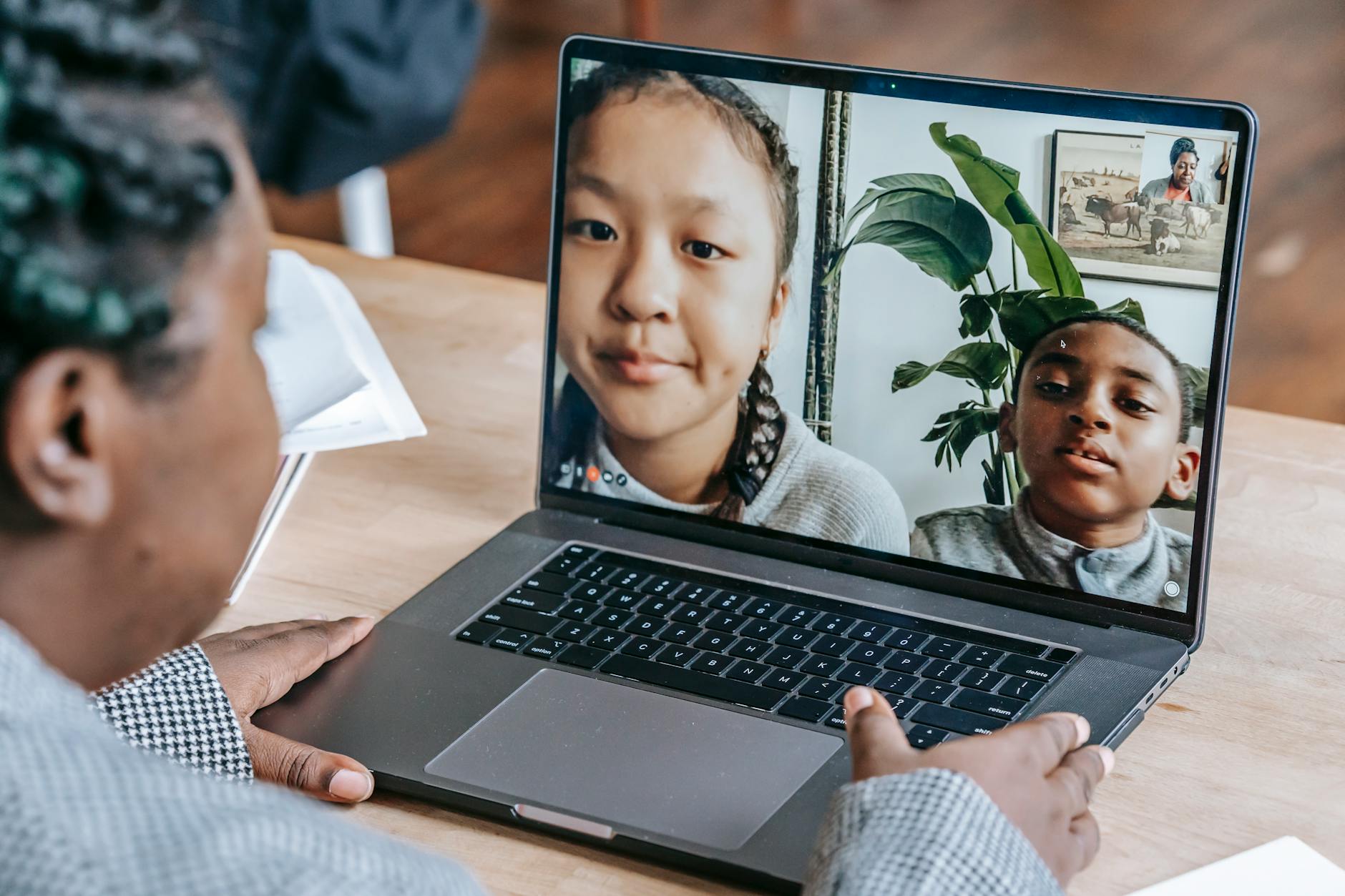 Back view of crop anonymous attentive African American teacher answer questions of pupils online on laptop — UPI Study